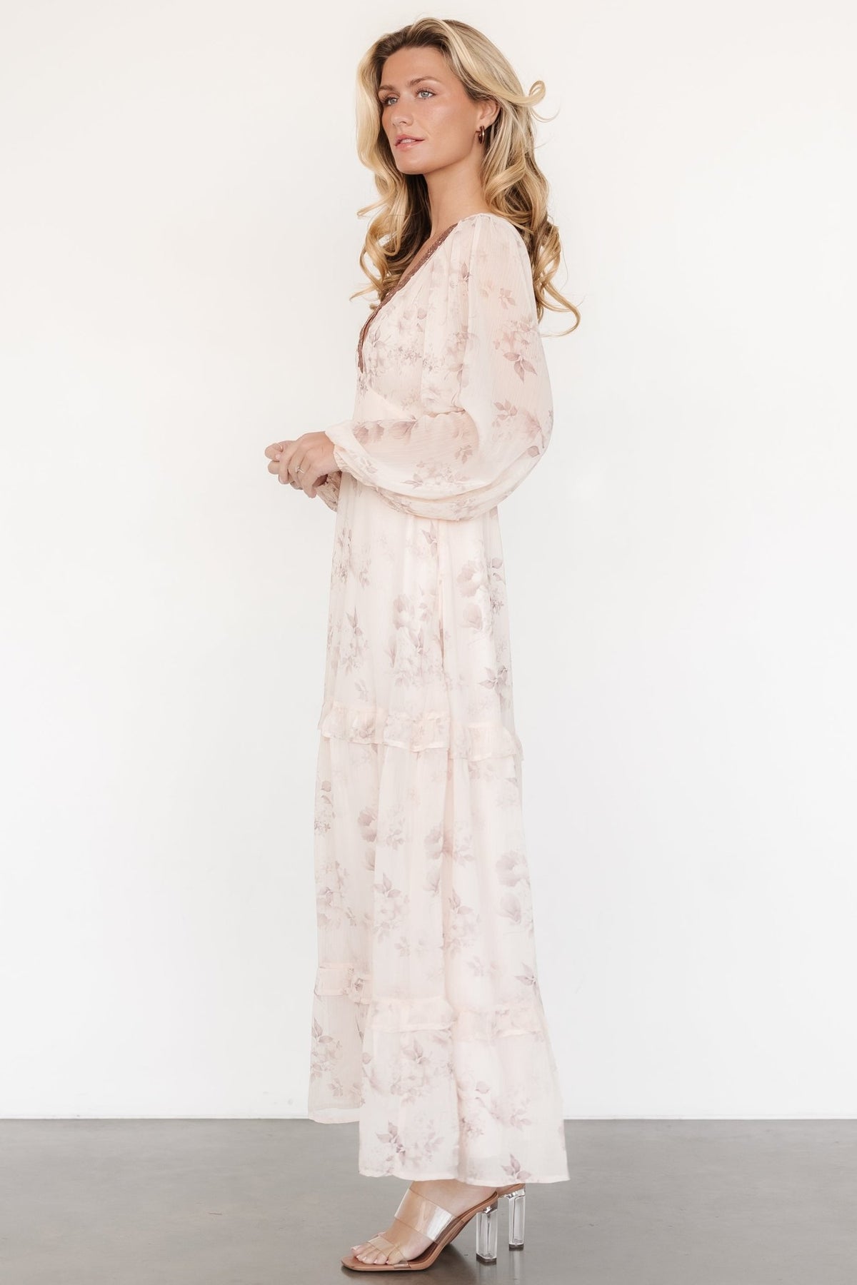 Styled full-length image of the beige and clove floral maxi dress on model, highlighting overall silhouette, flow and slit placement.