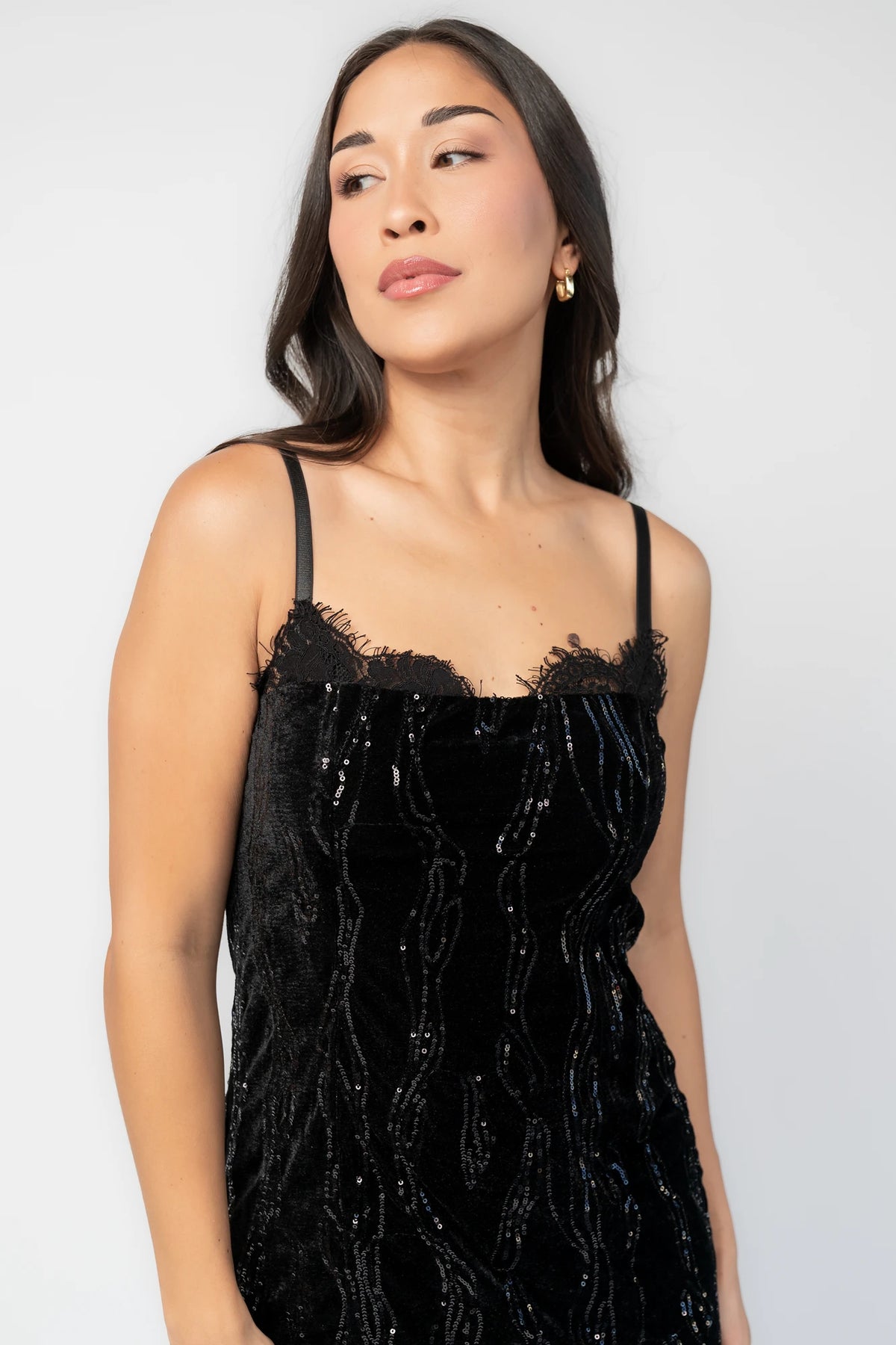 Sabina Sequin Midi Dress in Black with allover sequins, black lace neckline, spaghetti straps, and fitted silhouette.