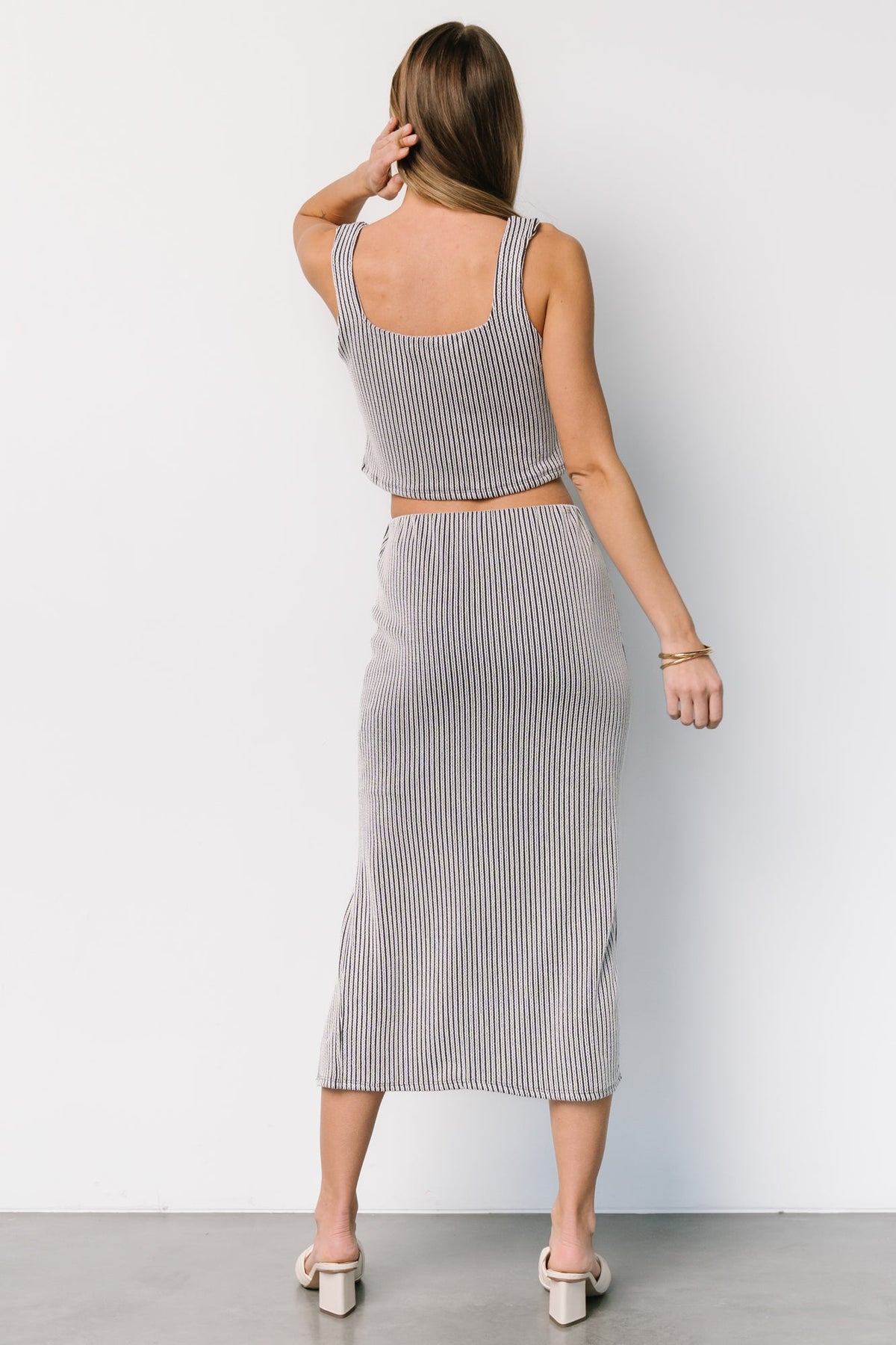 Close-up of fabric showing off-white and navy stripe pattern and soft, stretchy rayon-blend texture with subtle stretch.