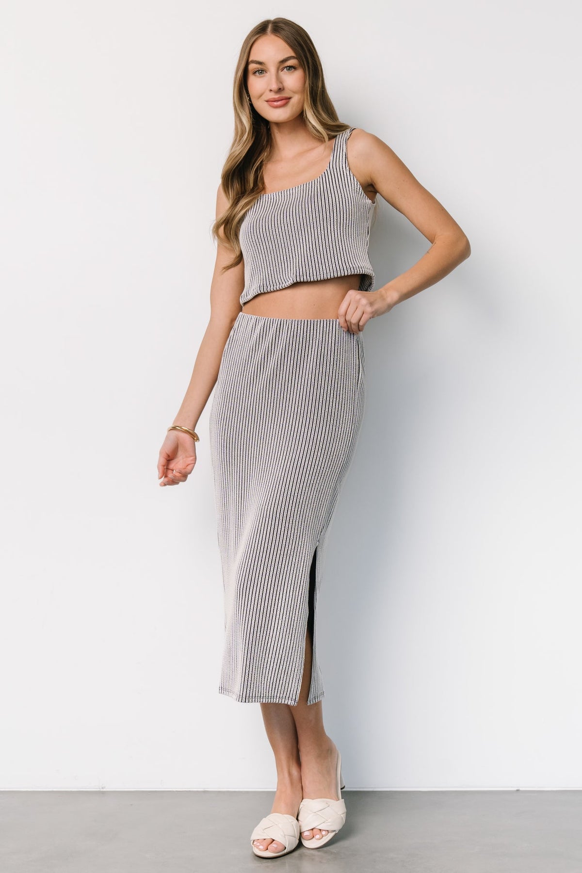 Back view of Sabrina set showing cropped tank length and smooth skirt fit at the natural waist on a standing model.