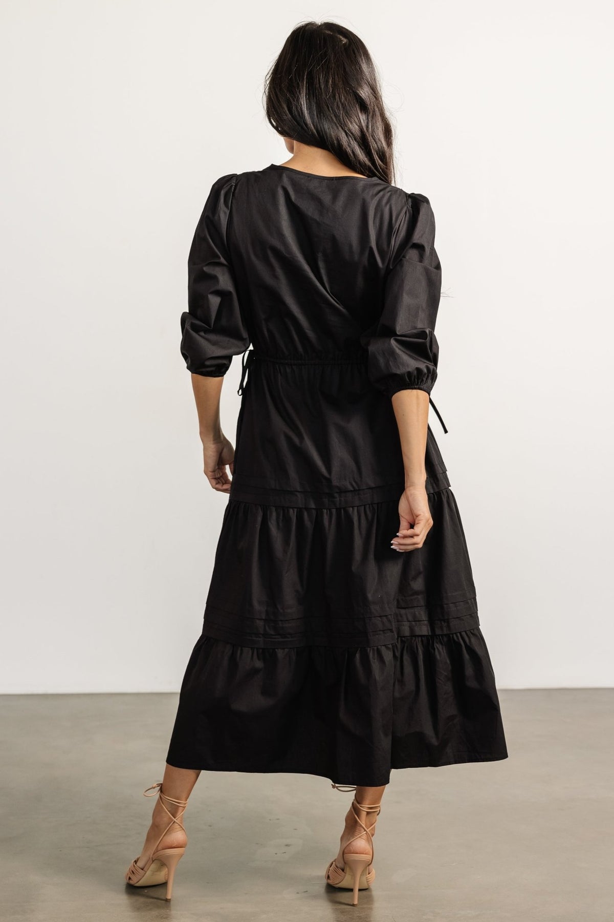 Side view of Santa Fe Poplin Midi Dress in black emphasizing the tiered skirt layers and the natural waist definition created by the self-tie sash.