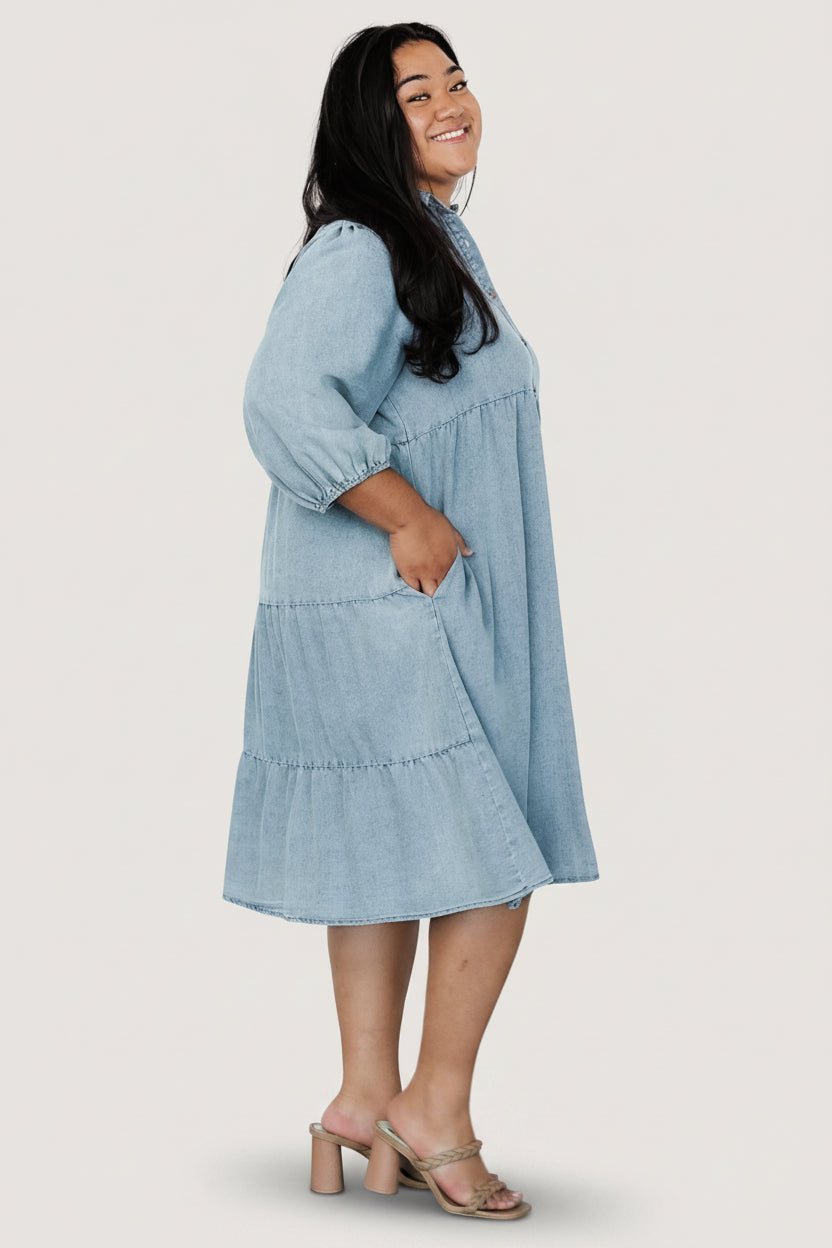 Studio image of Sari Chambray Babydoll Dress laid flat to show button-down front, collar, and subtle acid-wash finish.