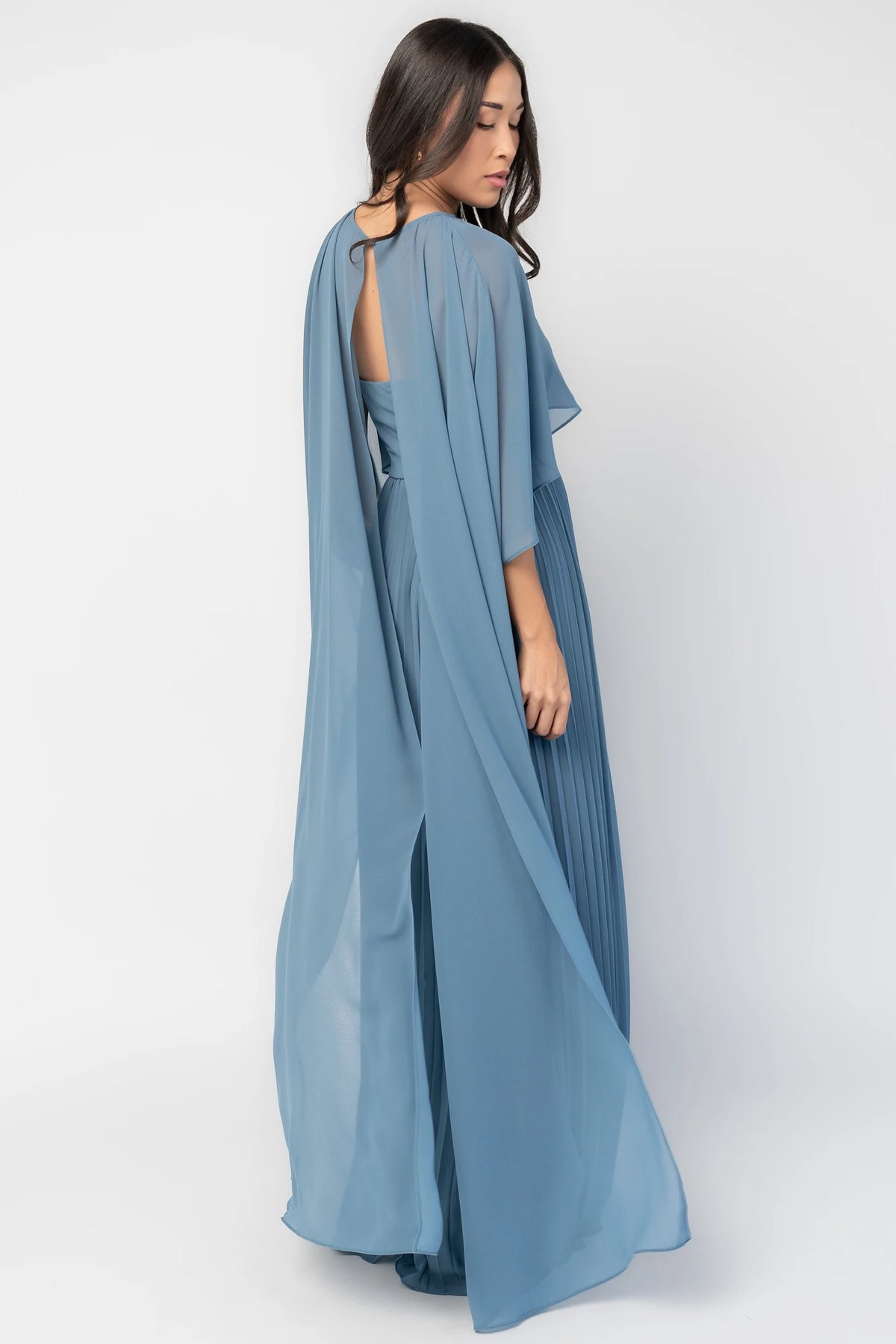Serafina Strapless Gown in Blue with strapless neckline, removable sheer cape overlay, defined waist, and pleated skirt.