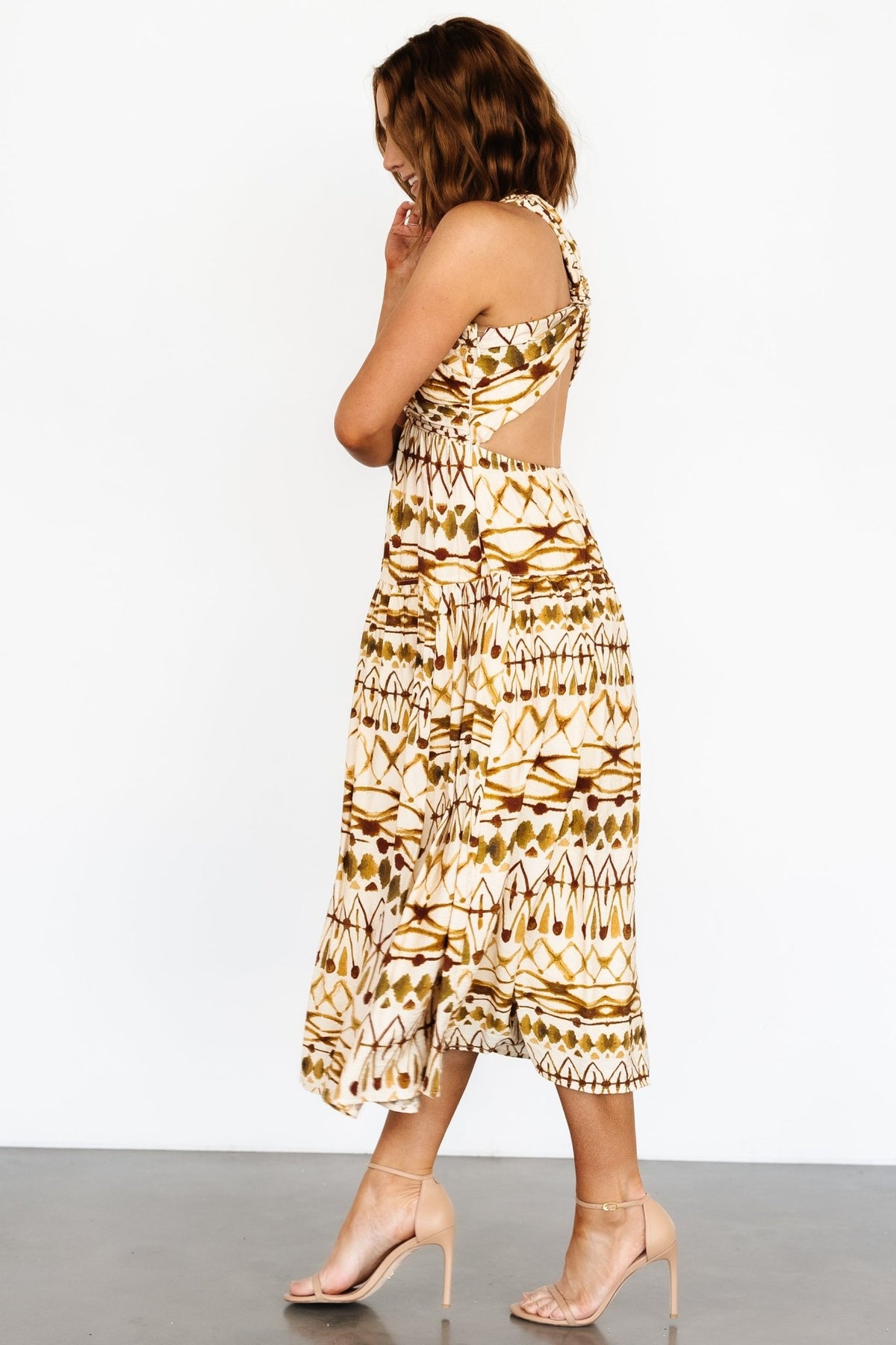Model wearing tan multi Seraphina dress with sandals, showcasing midi length, movement, and warm-weather-ready styling.