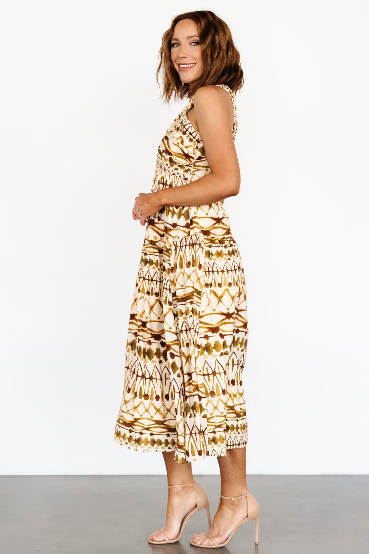 Back detail of the tan multi dress showing tank sleeves that crossover with a knot and the open-back design.