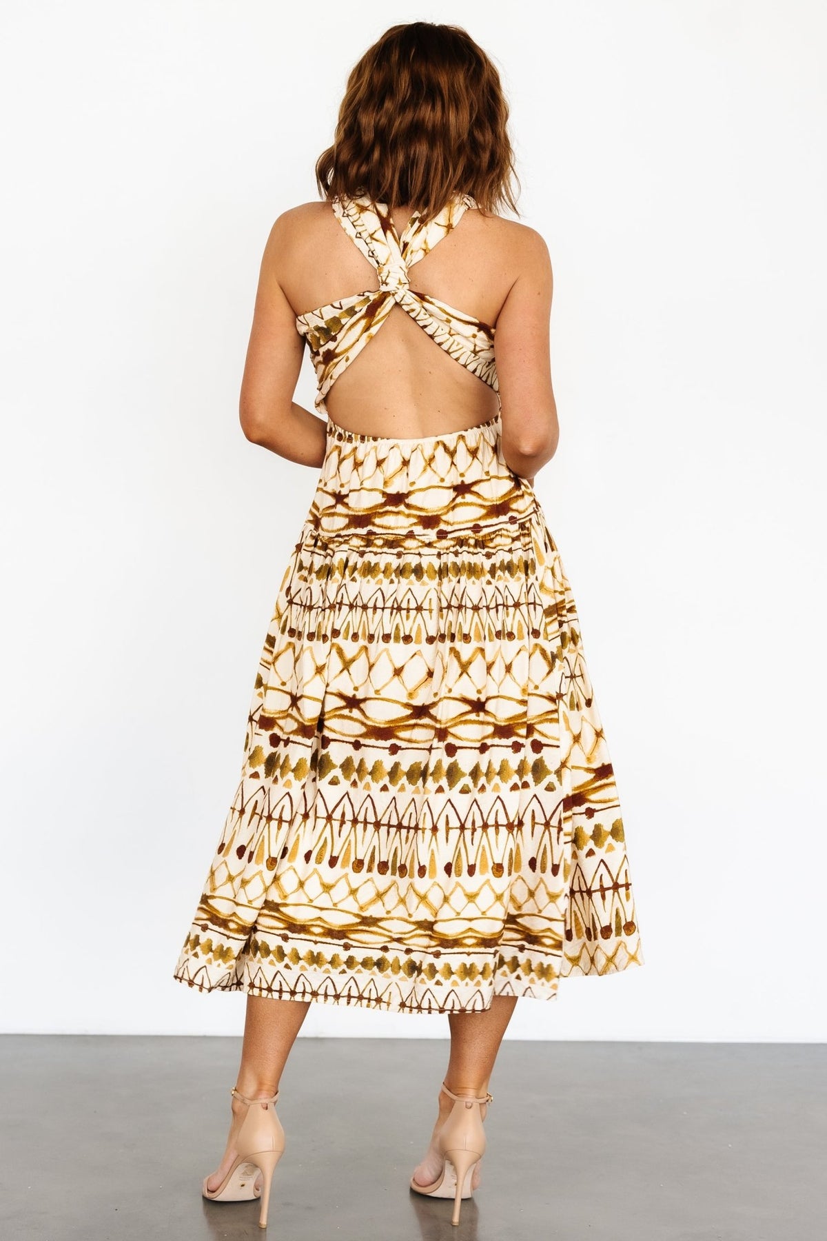 Three-quarter view of the tan multi Seraphina midi dress highlighting soft drape, gathered detailing and flattering empire waistline.