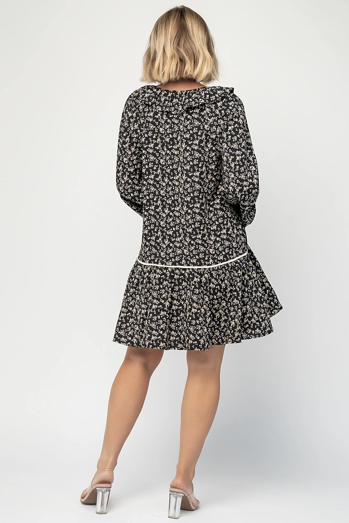 Shantel Bow Front Short Dress in Black Floral with ruffled neckline, faux bow front, long sleeves, and short skirt.