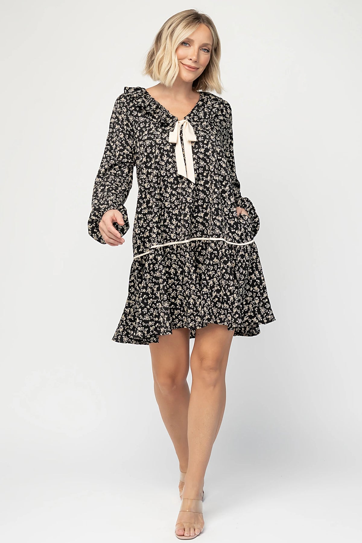 Shantel Bow Front Short Dress in Black Floral with ruffled neckline, faux bow front, long sleeves, and short skirt.