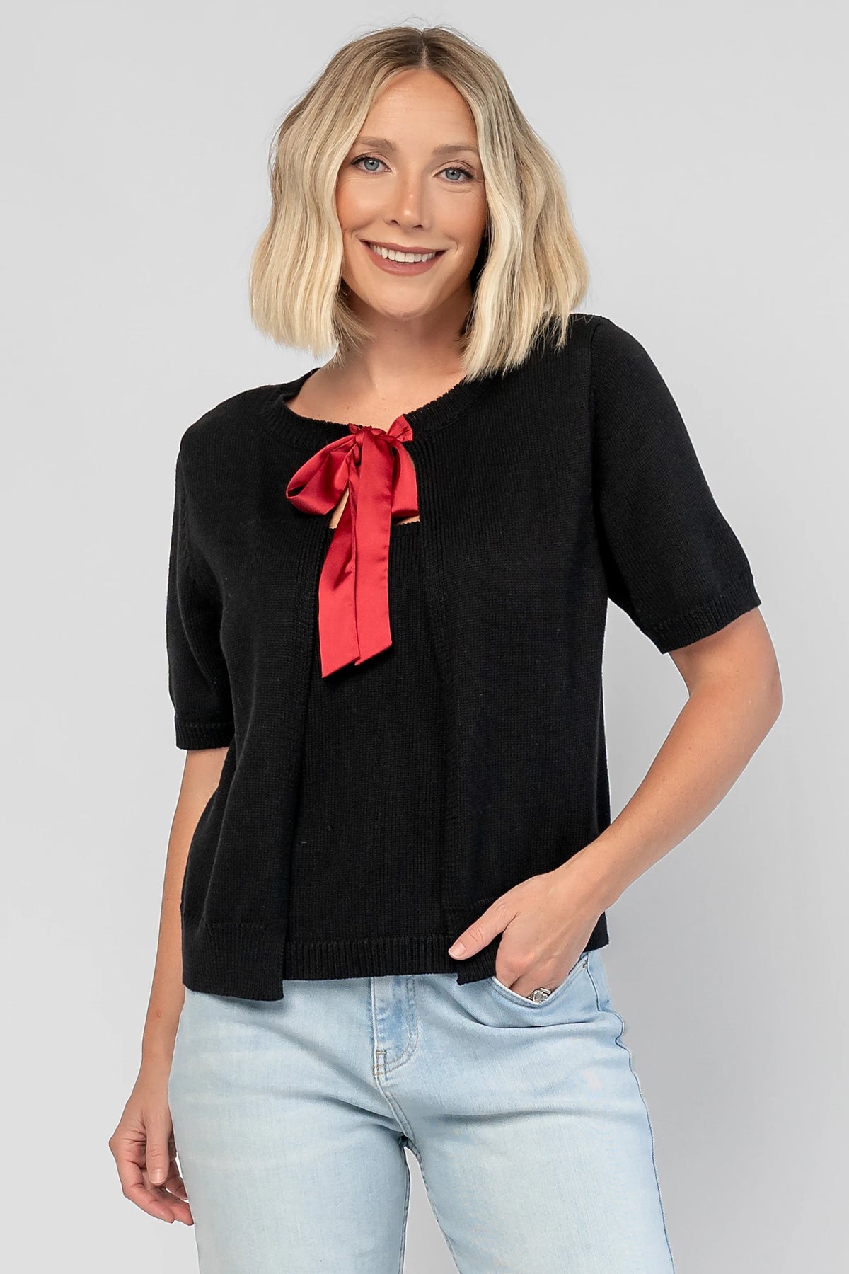 Shaye Sweater Top in Black with a built-in tank, satin bow tie closure, and soft knit construction.