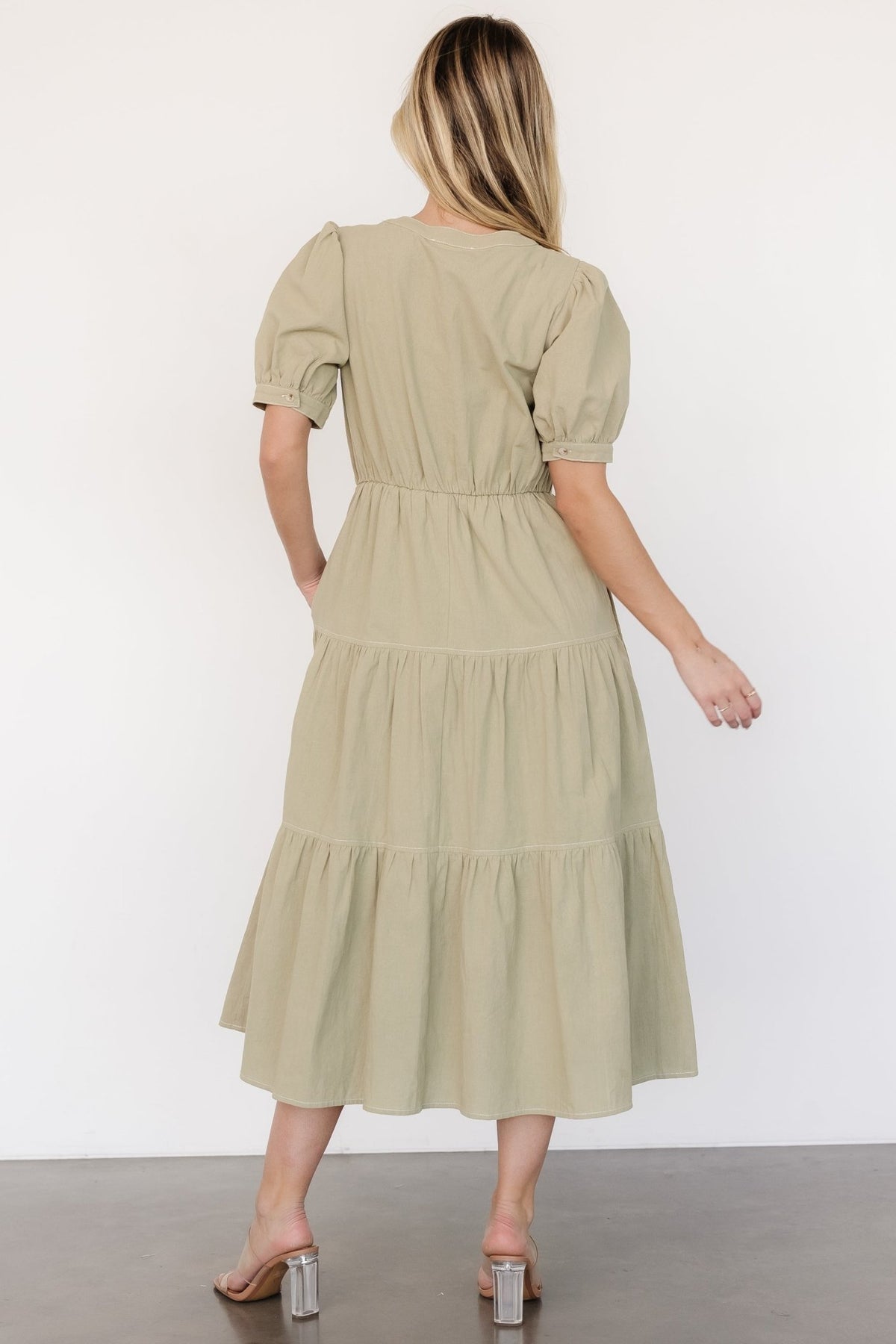 Back view of sage green midi dress showing elastic back waist and tiered skirt silhouette suitable for everyday styling.