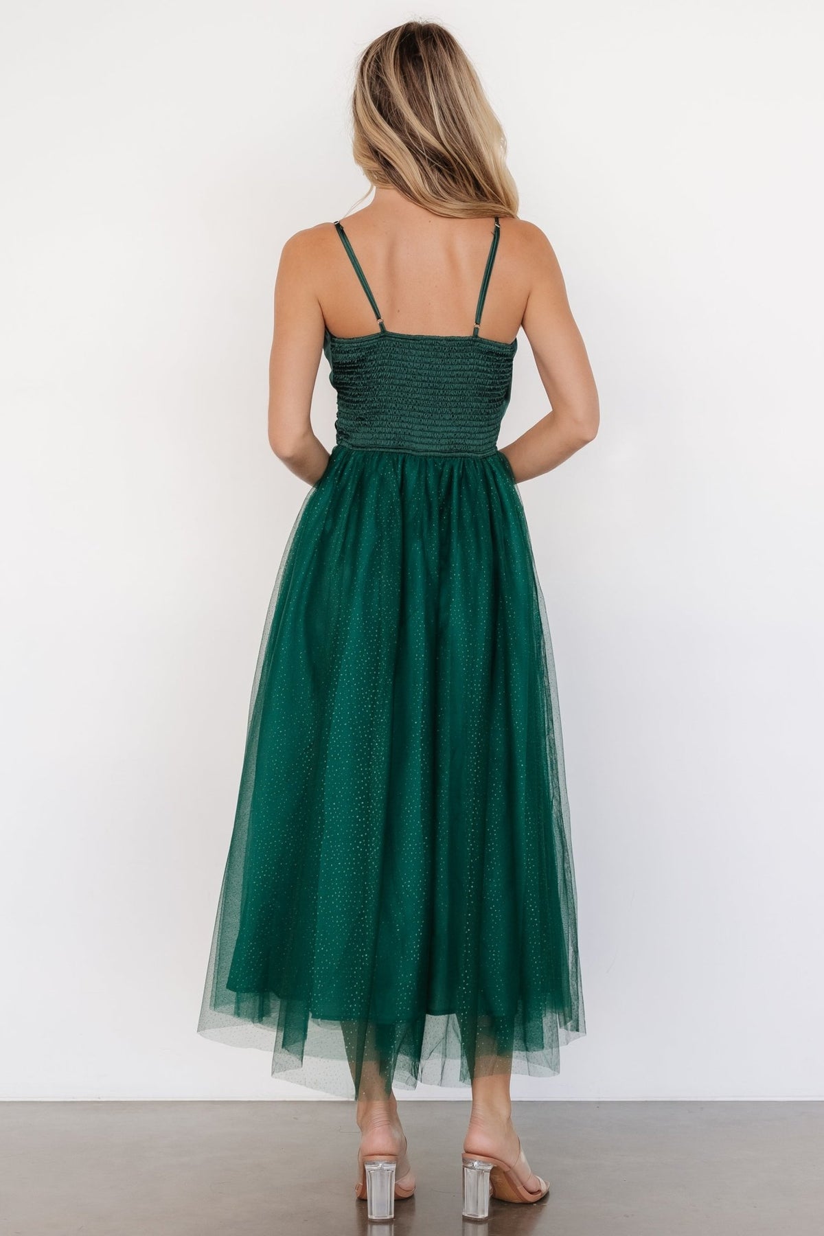 Side view of Shonda Sparkle midi dress in emerald showing skirt movement, adjustable straps, and mid-length tulle silhouette.