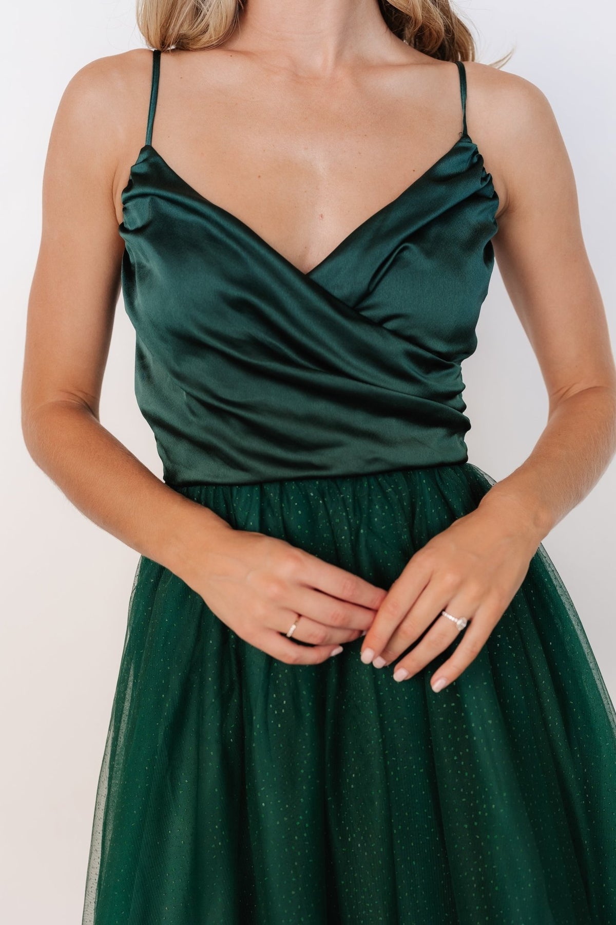 Three-quarter view of the Shonda Sparkle midi dress in emerald highlighting smocked back, fitted bodice, and shimmer-dotted tulle layers.