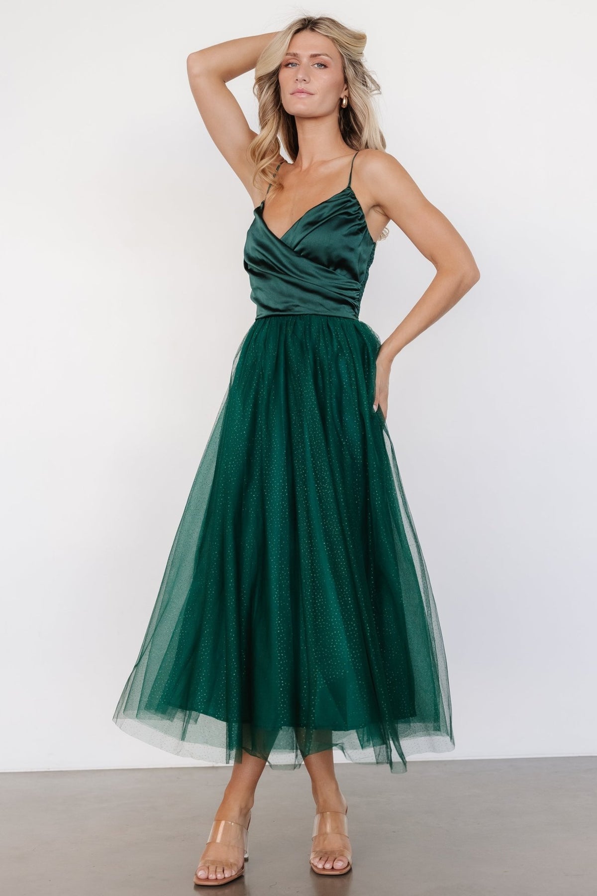 Close-up of the satin-like crossed bodice and embellished shimmer dots on the emerald tulle skirt of the Shonda Sparkle midi.