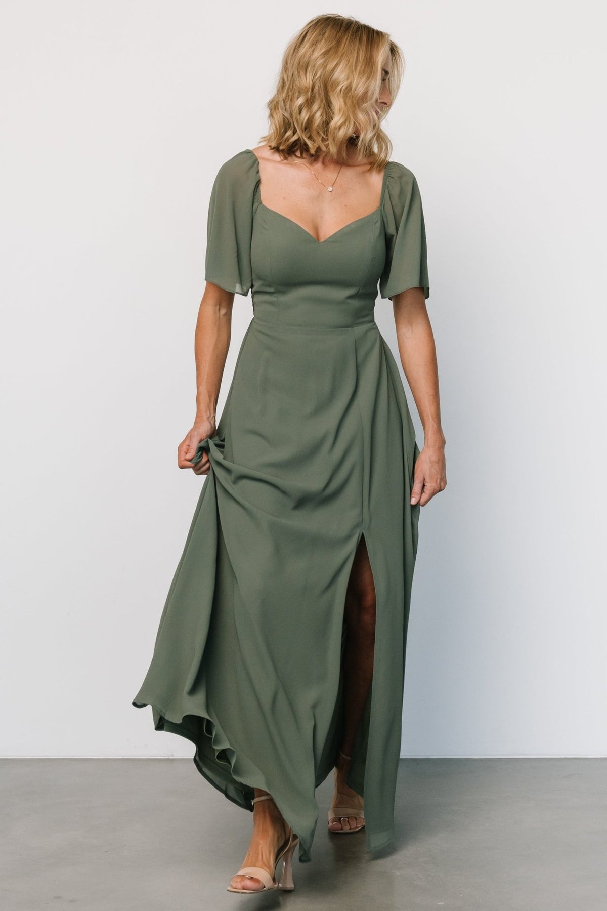 Side view of Sierra Sweetheart Maxi Dress in dark sage highlighting the front left slit and flowing chiffon skirt movement.