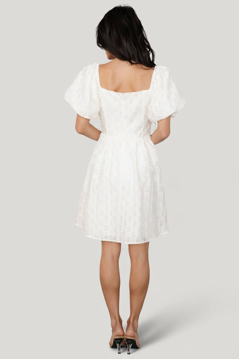 Back view of cream Sommer Short Dress displaying back zipper closure, gathered elastic shoulder detail, and the dress’ short, fully lined skirt.