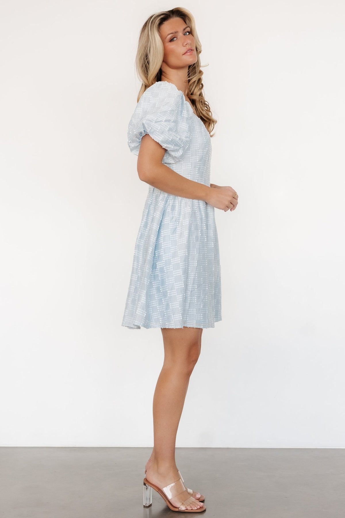 Close-up of textured burnout fabric and patterned detail on the Sommer Short Dress in light blue, showing sleeve cuff and elastic shoulder.