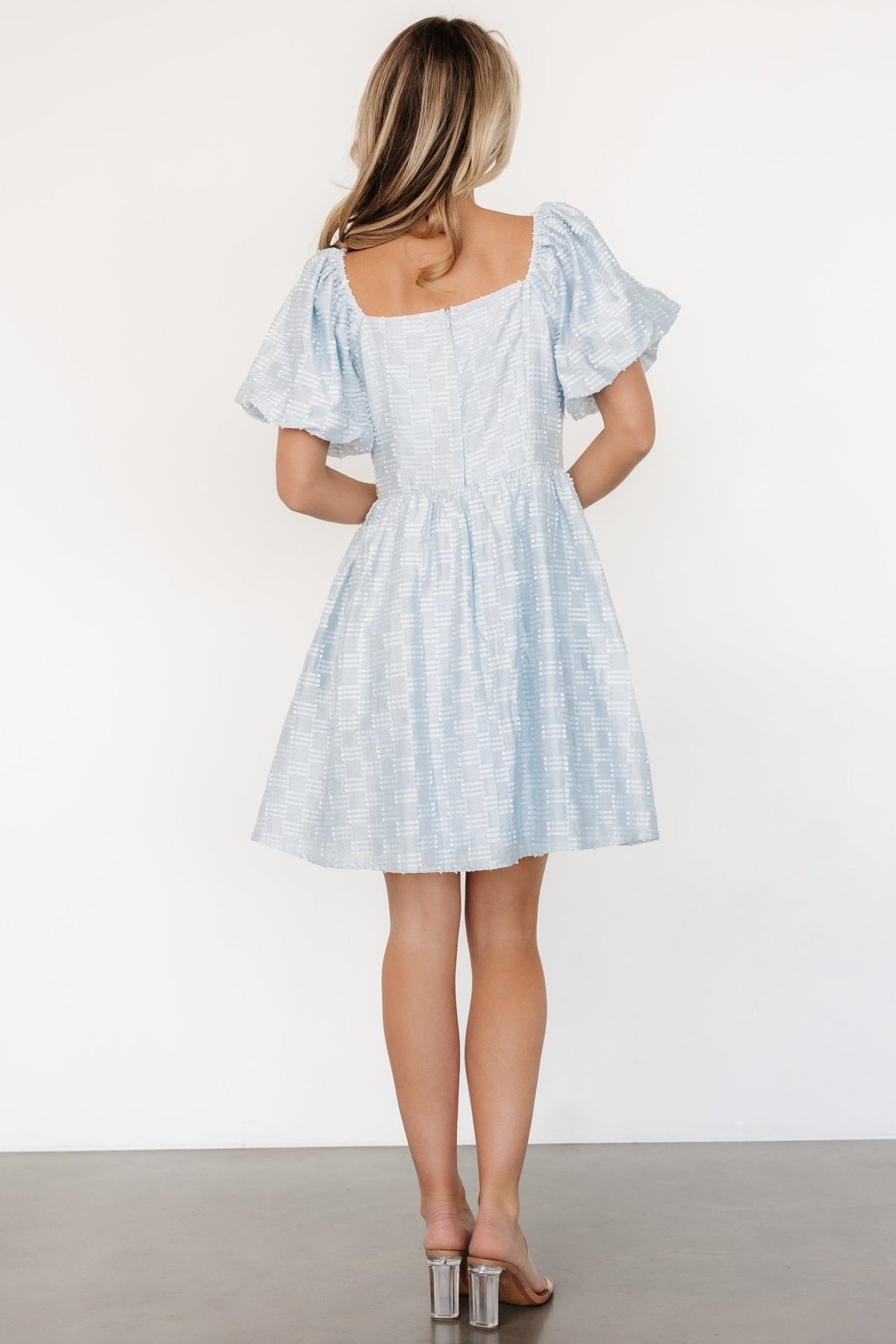 Sommer Short Dress styled with sandals, showing full silhouette in light blue, oversized sleeves and fully lined short skirt.