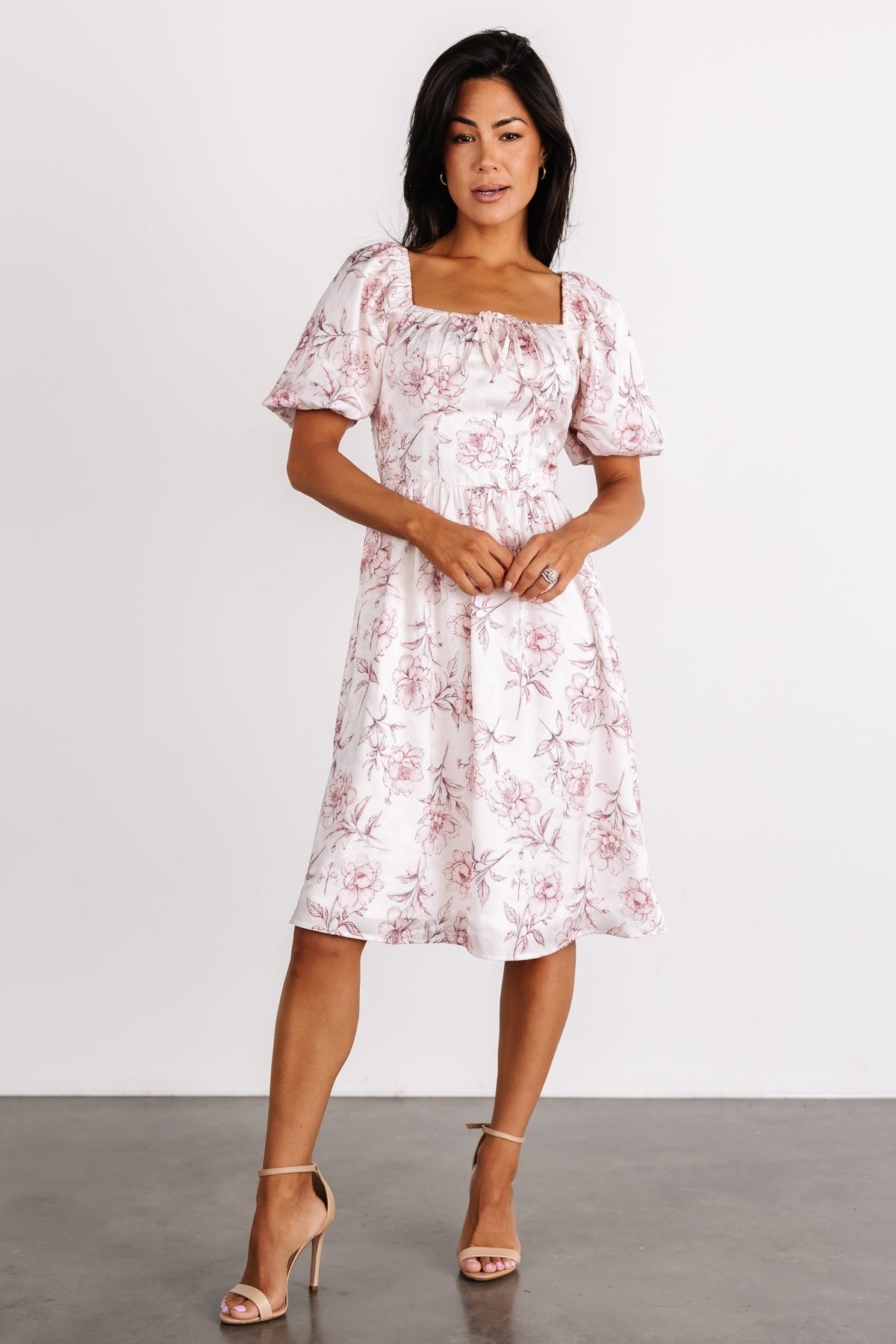 Back view showing smocked back bodice and fitted waist of the Sonnet Short Dress in blush floral, illustrating stretch and shape.