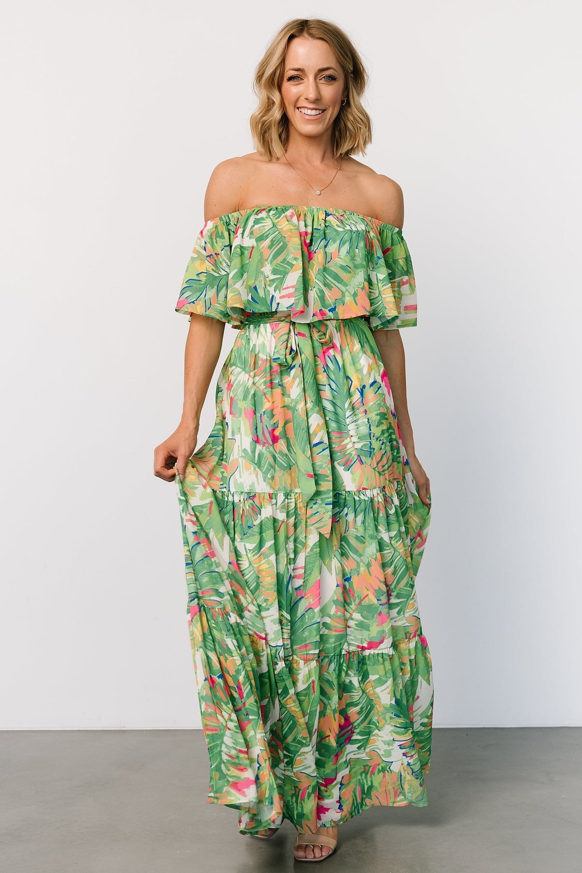 Front view of Sonoma off-shoulder maxi dress in green multi tropical print, elastic neckline, removable self-tie belt, and tiered skirt.