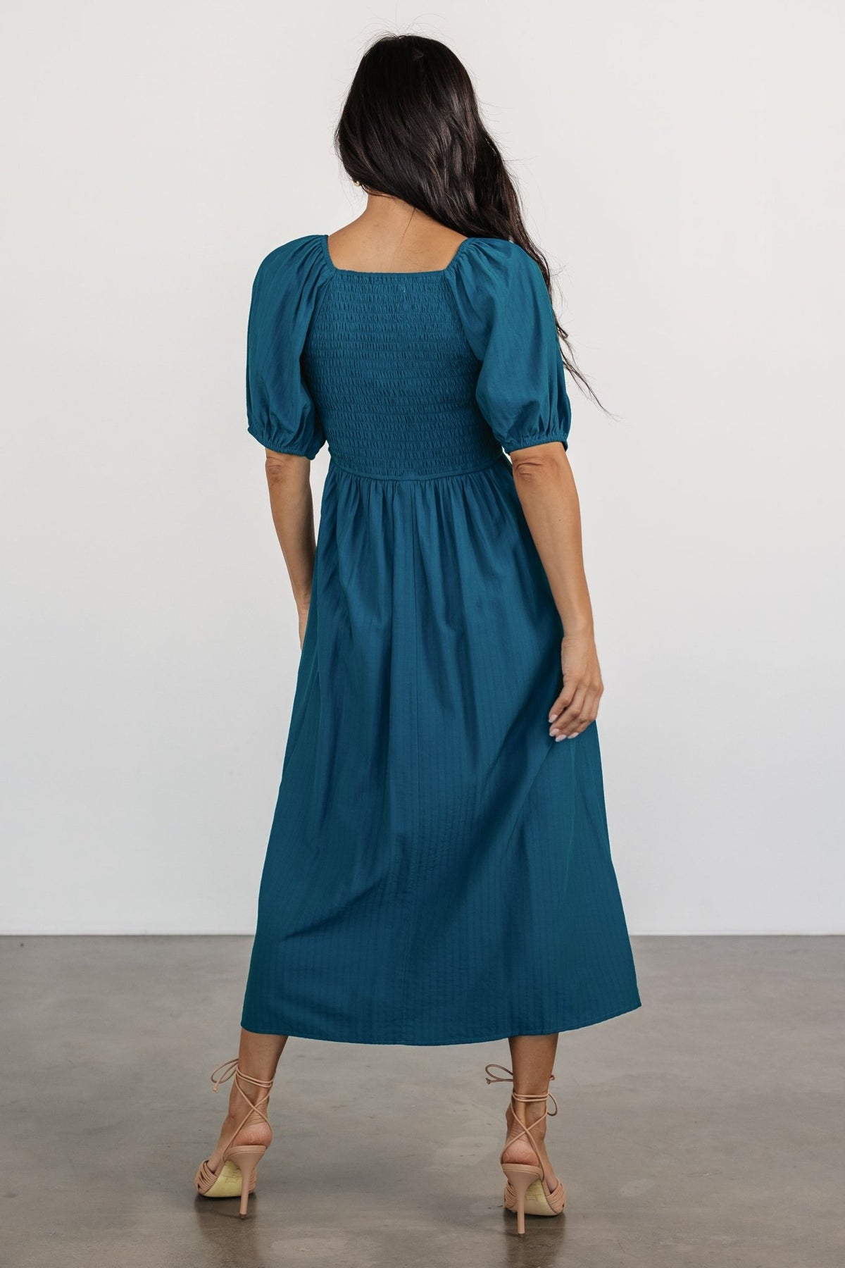 Side view of the Stefania Midi Dress in Mediterranean Blue on model, showing midi length, A-line skirt silhouette, and practical hidden side pocket.