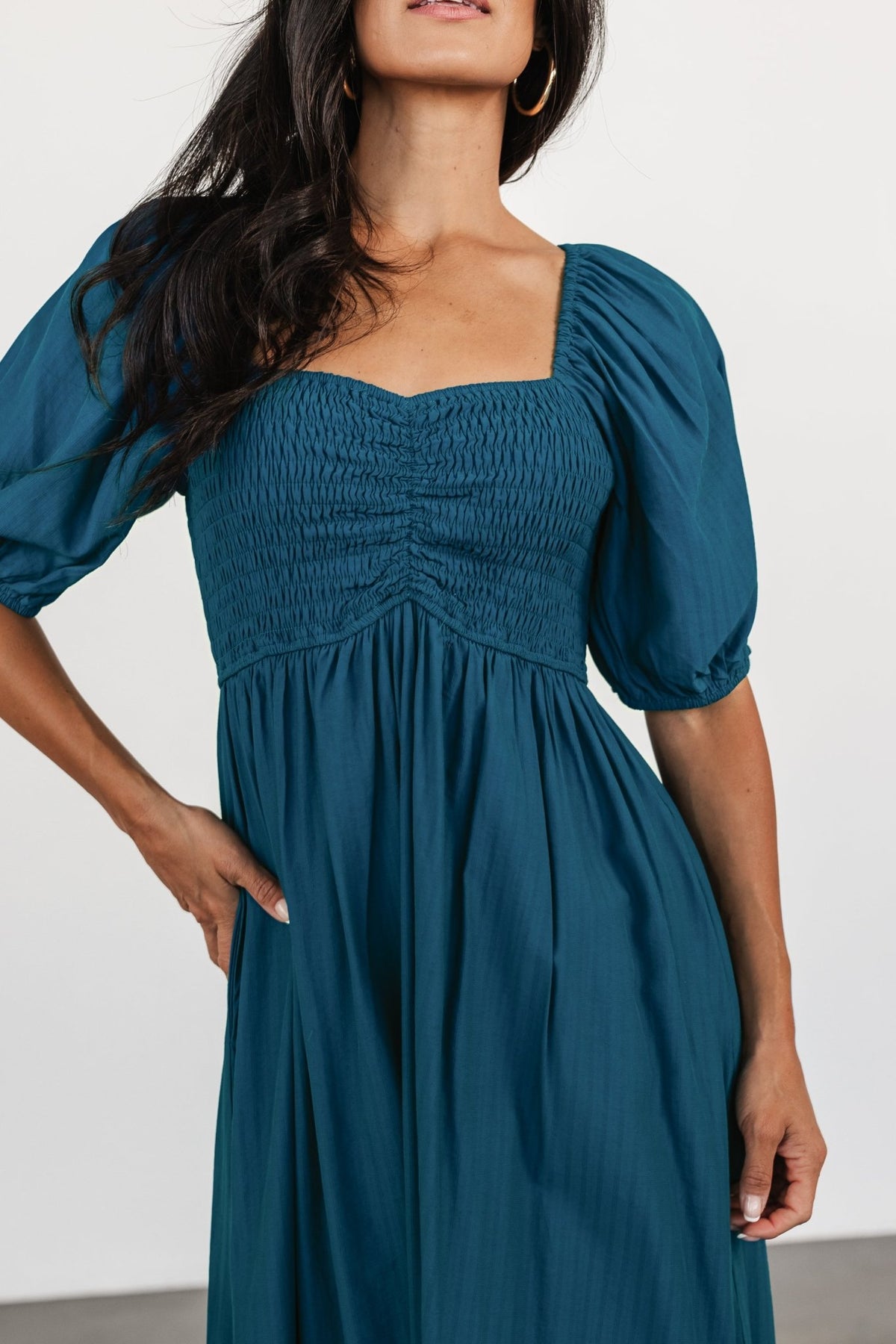 Three-quarter angle of Stefania Midi Dress showing raglan balloon sleeves, ruched center seam on bodice, and the dress’s textured pin-striped chiffon fabric.