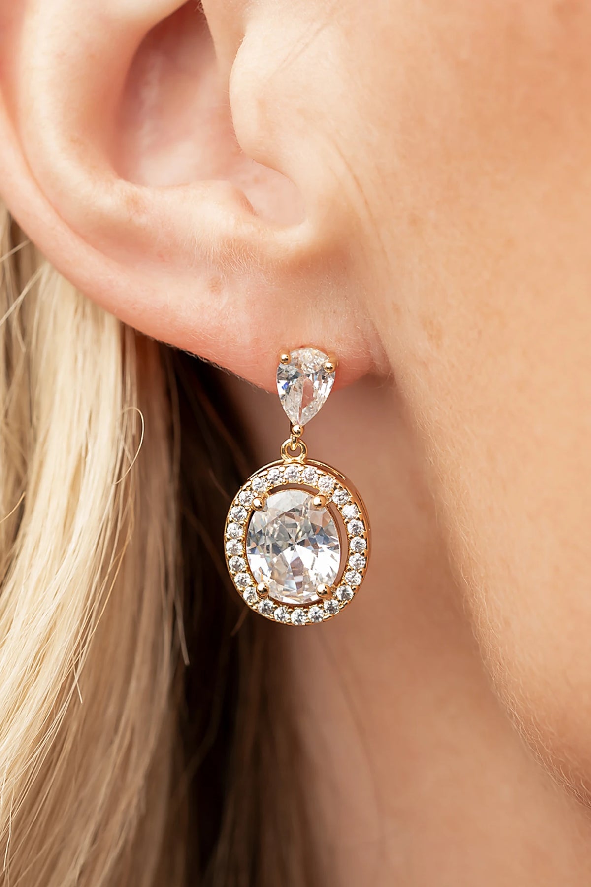Stena Oval Dangle Drop Earrings in Gold with oval center stone and pavé stone border.