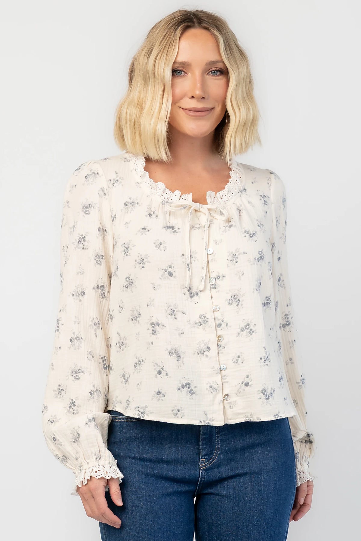 Stephanie Button Front Blouse in Ivory + Blue Floral with a lace-trimmed tie neckline and a button-front design.