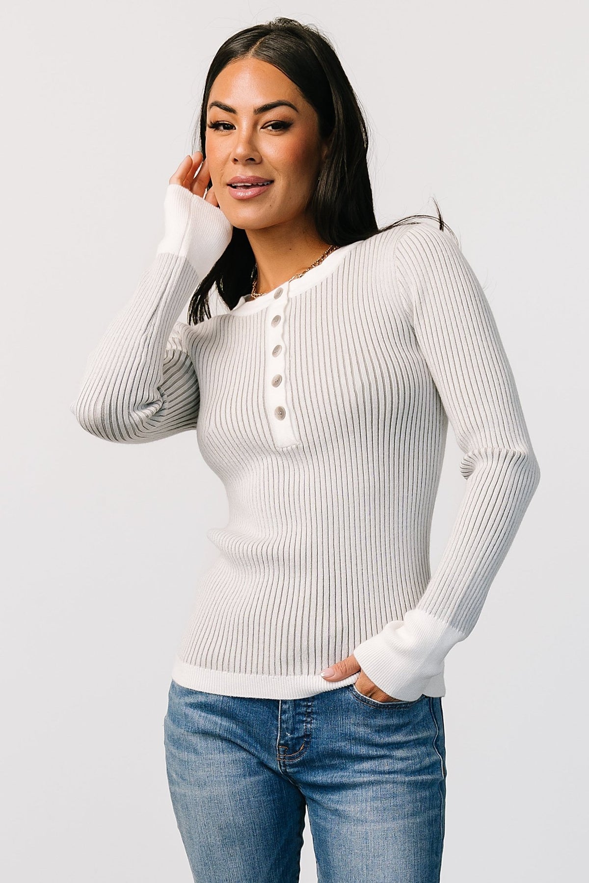 Model wearing Stevie ribbed henley sweater in light gray with off-white trim; relaxed fit, ribbed texture, and subtle contrast cuffs visible.