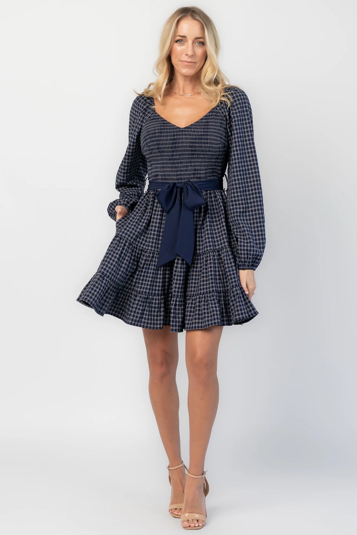 Stina Short Dress in Navy Plaid with smocked V-neck bodice, long sleeves, and tiered skirt.