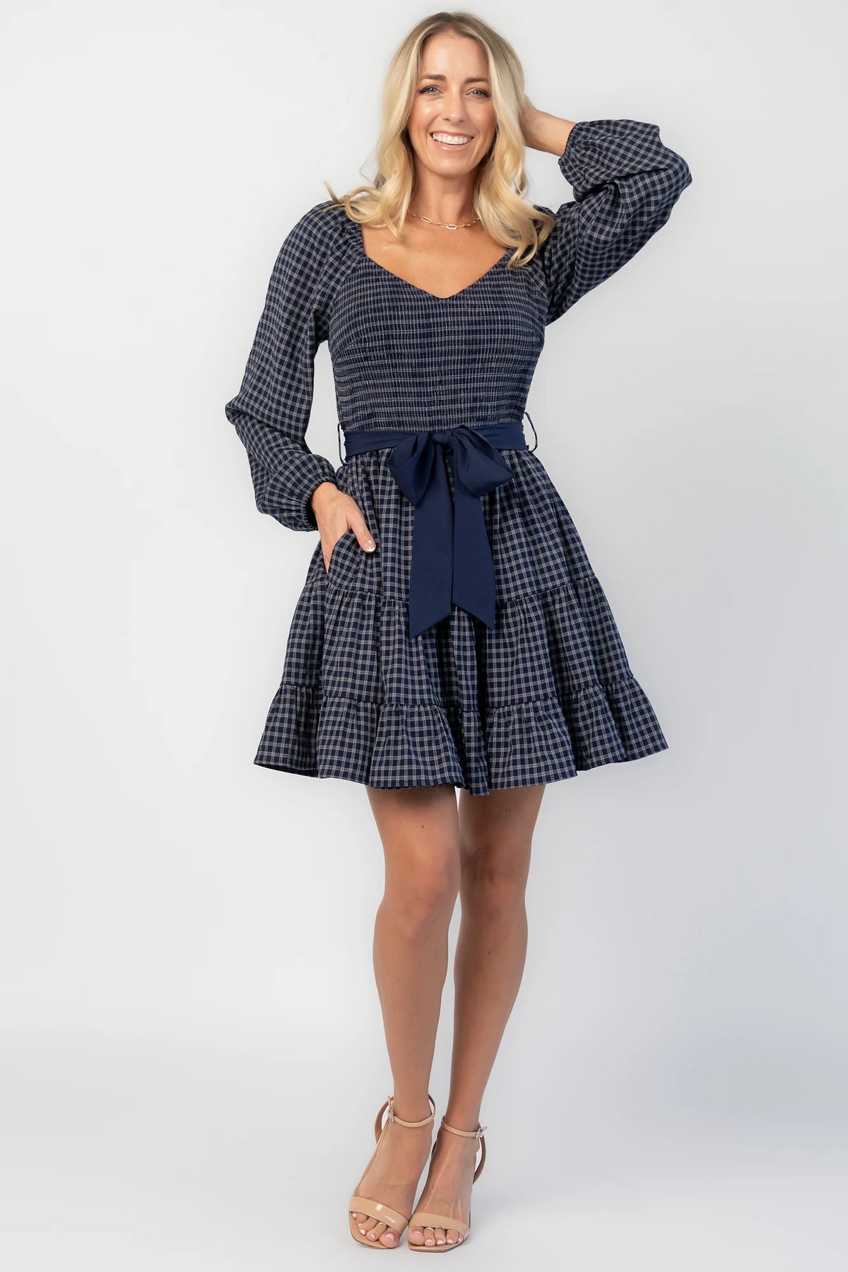 Stina Short Dress in Navy Plaid with smocked V-neck bodice, long sleeves, and tiered skirt.