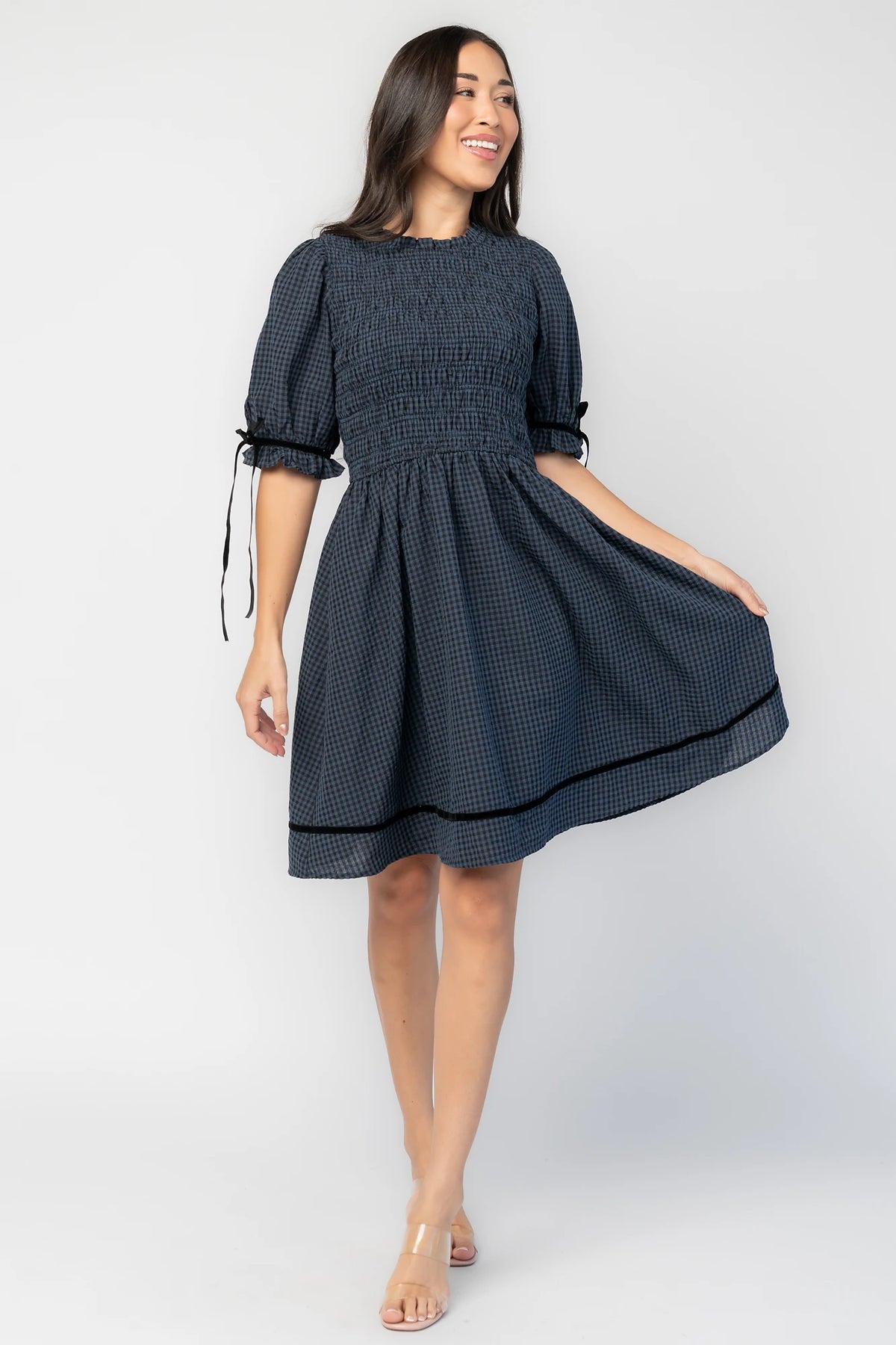Susan Short Dress in Navy + Black Gingham with smocked bodice, elbow-length sleeves, black velvet ties, and velvet-trimmed hem.