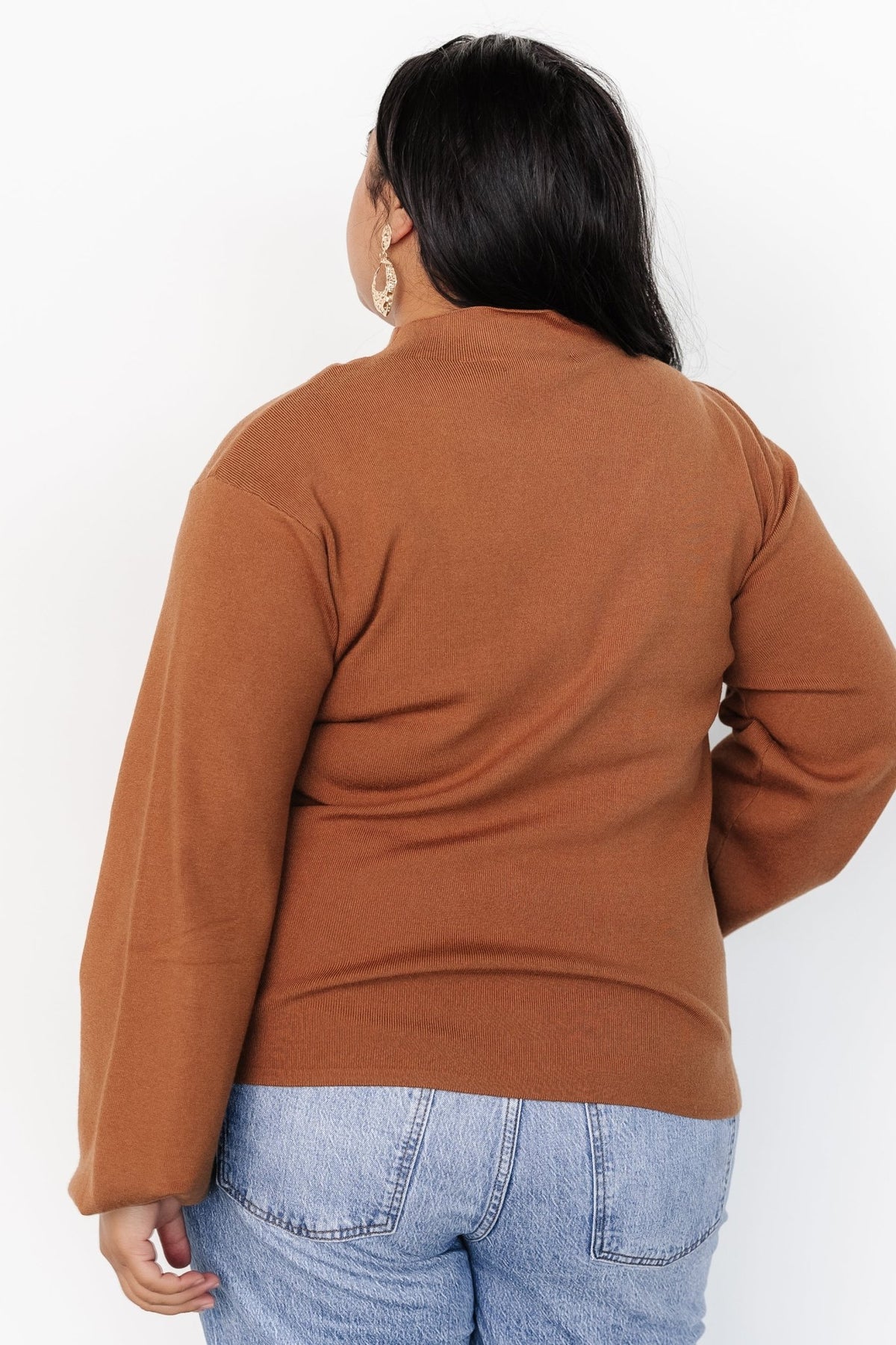 Styled look of Sutton Sweater Top in teddy-bear brown worn layered under a coat, demonstrating versatility for fall and winter outfits.