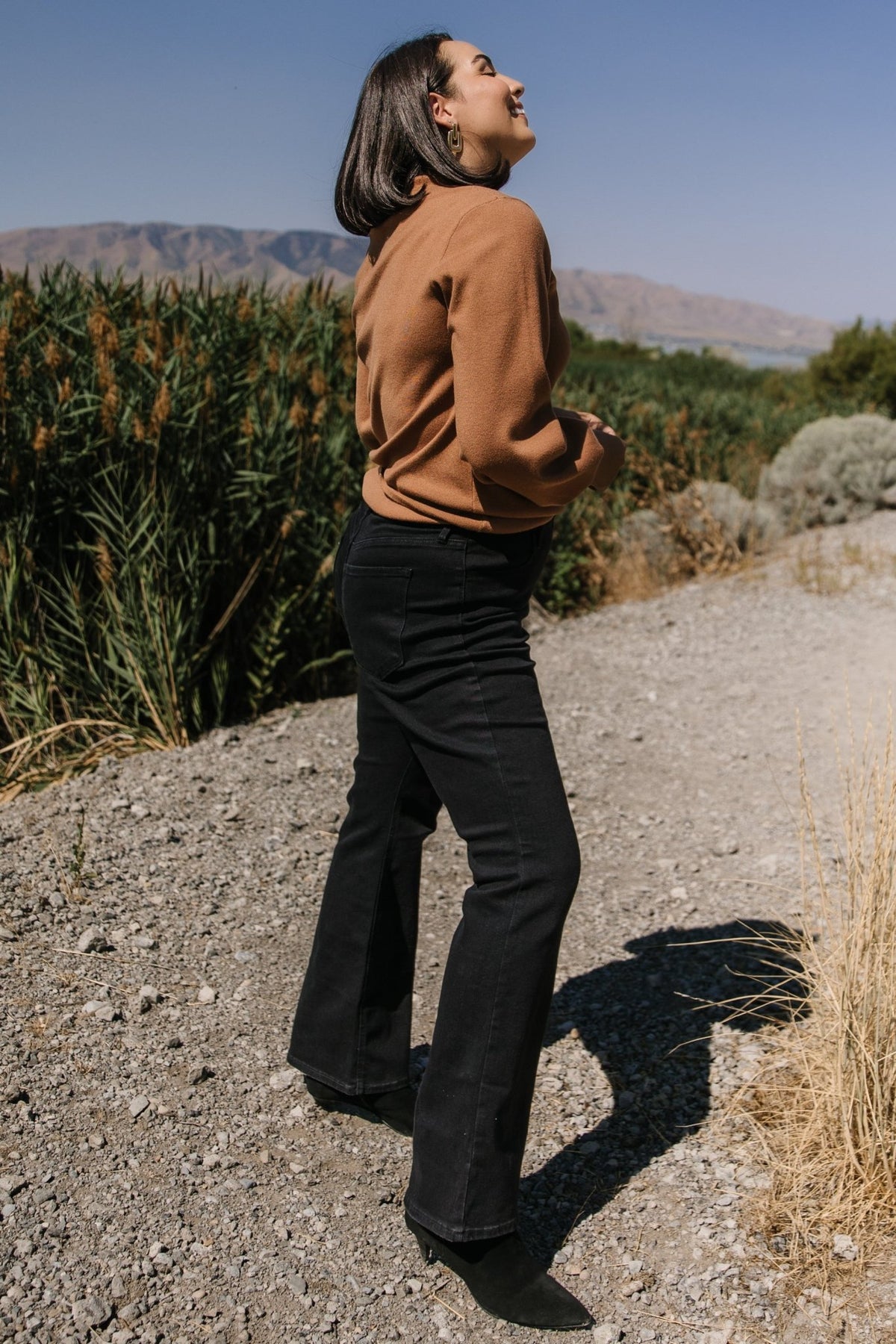 Detail shot of ribbed cuff and sleeve of the Sutton Sweater Top in brown, highlighting the knit finish and structured cuff construction.