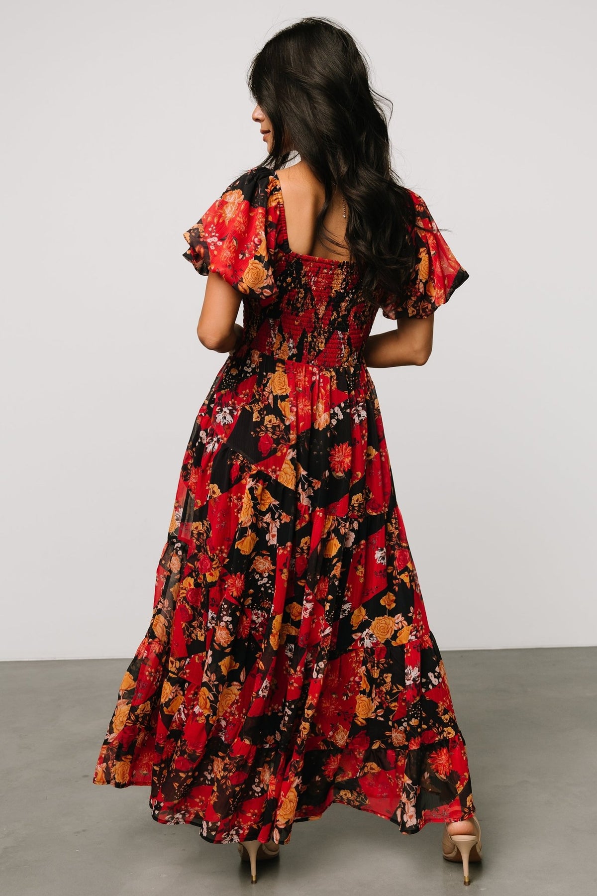 Pattern and hem detail of Suzy Maxi Dress in Black + Red Multi showing diagonal seam construction on the three-tier skirt and finished hemline.