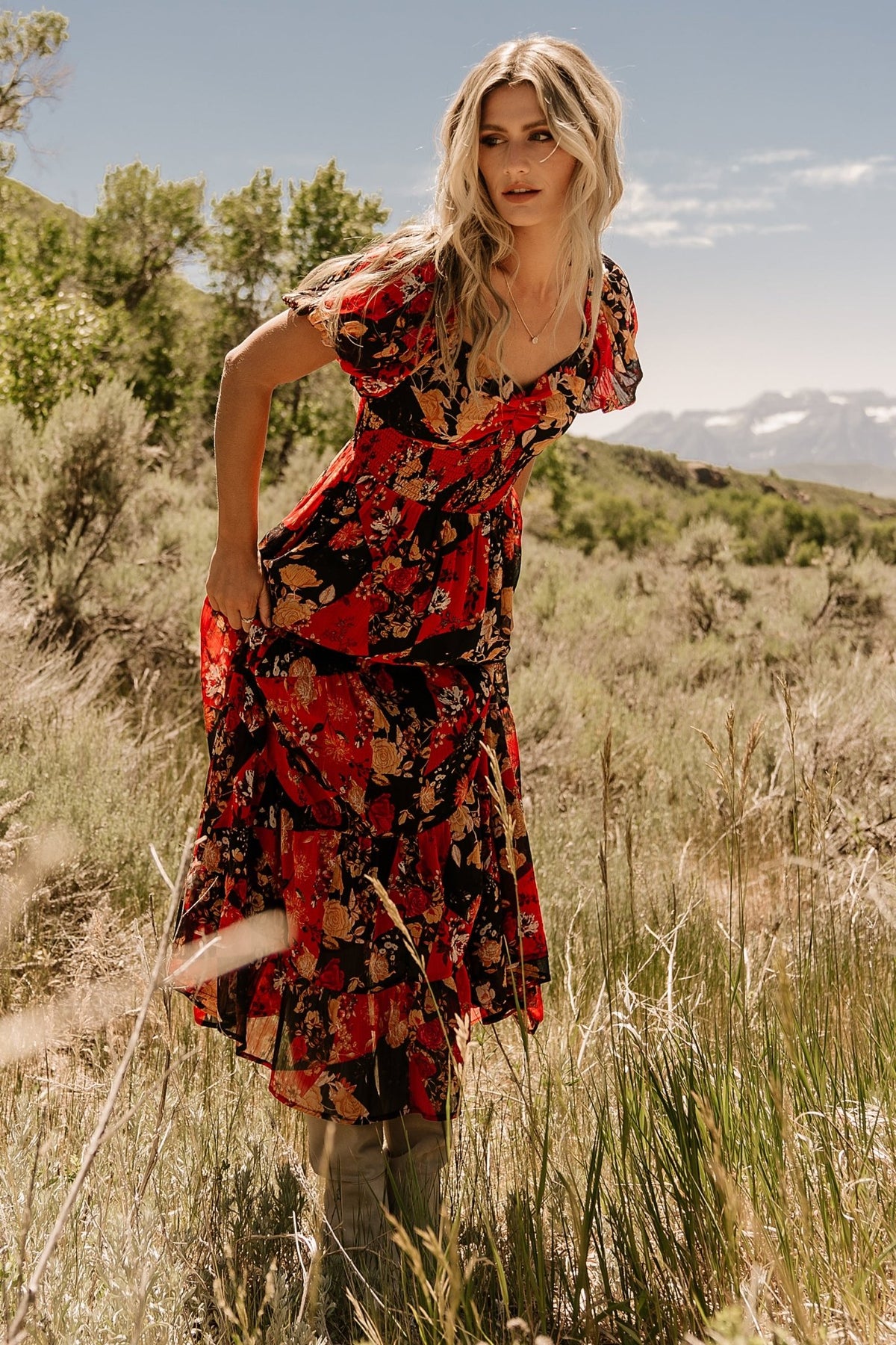 Three-quarter view of Suzy Maxi Dress in Black + Red Multi highlighting the tiered maxi skirt with diagonal seams and natural drape.