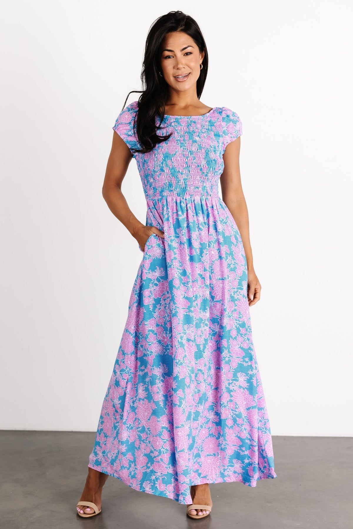 Front view of Tabitha Open Back Maxi Dress in blue gingham with pink floral print, showing smocked bodice, boat neck, and short puff sleeves.