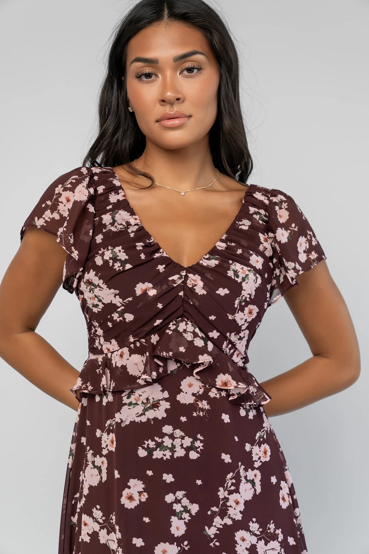 Teuila Midi Dress in Dark Clove + Blush Floral with V-neckline, ruched bust, flutter sleeves, and ruffle skirt.