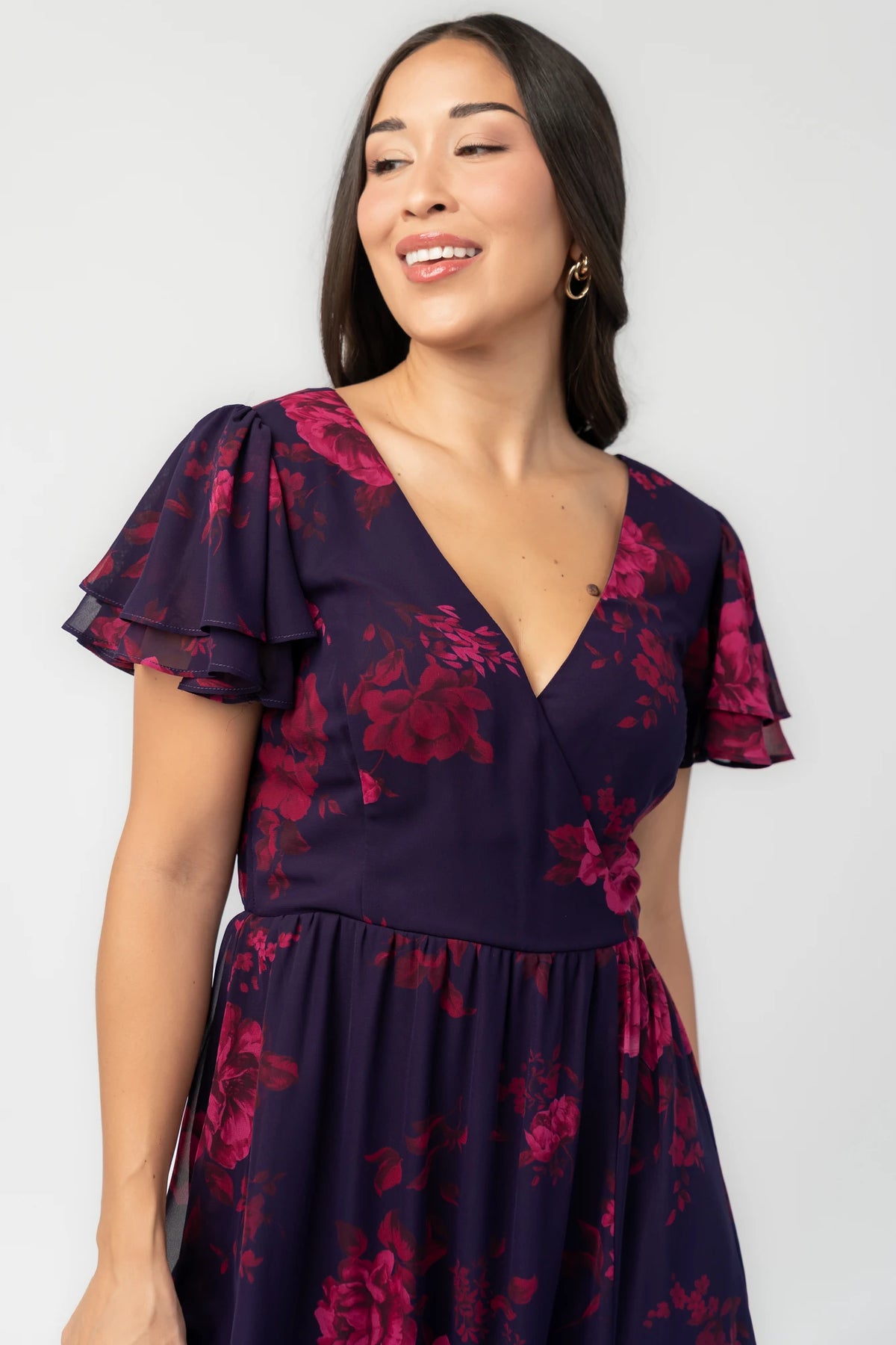 Theodora Maxi Dress in Indigo + Berry with floral print, crossover V-neck, flutter sleeves, elastic waist, and leg slit.