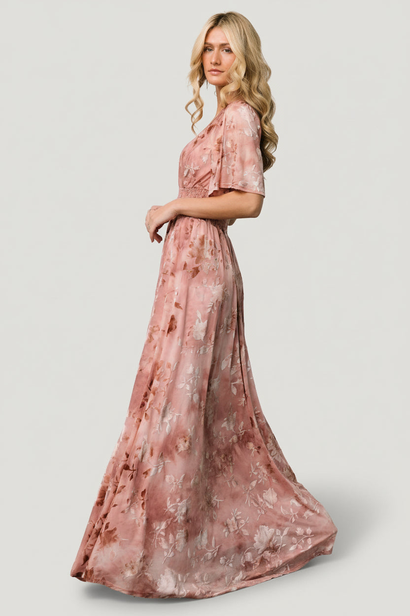Close-up of blush embossed velvet fabric and smocked waist on the Veronica Maxi Dress showing texture and stretch detail.