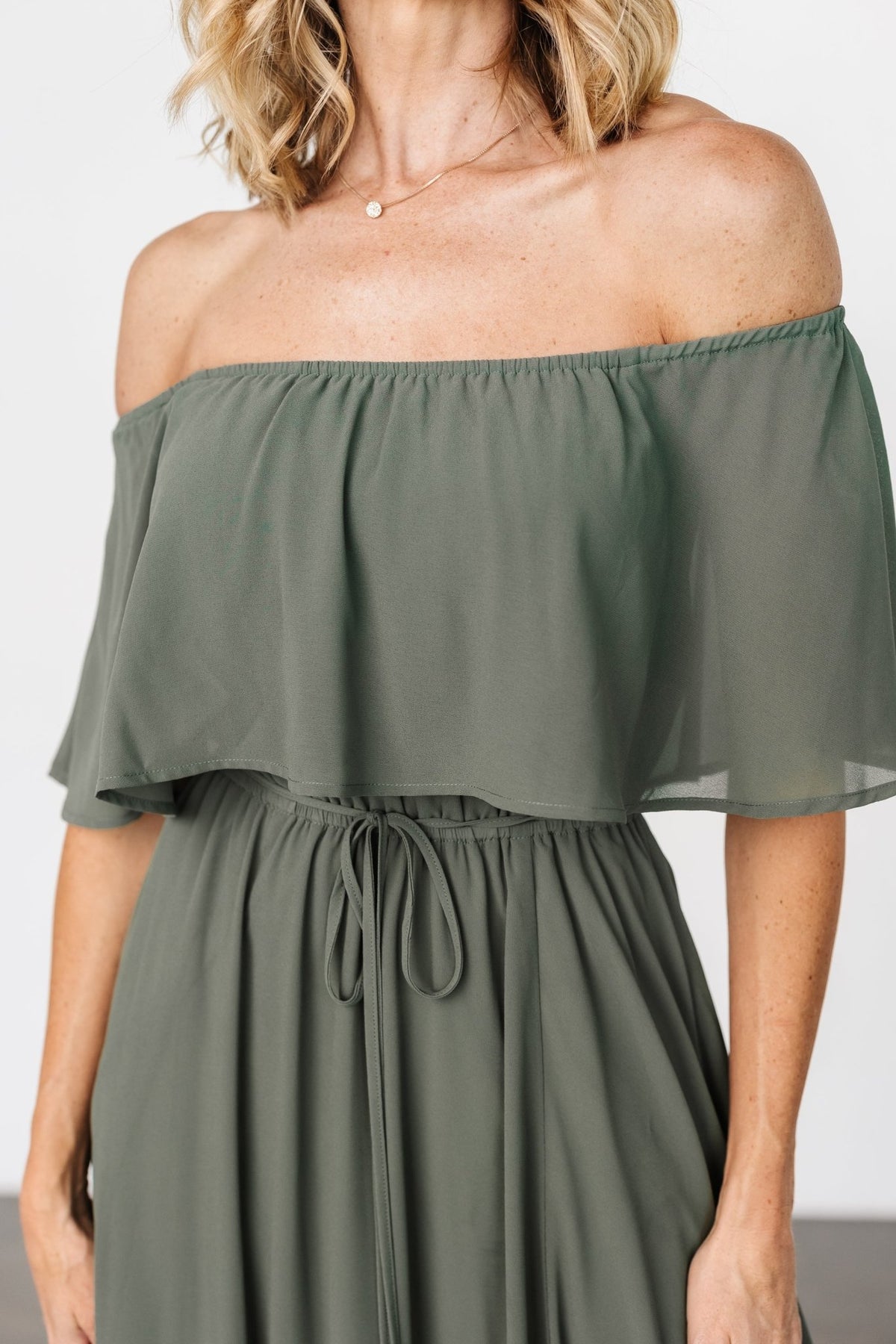 Close-up of the dress bodice highlighting elastic top hem, off-shoulder sleeves, and soft gathered detail across the waist.
