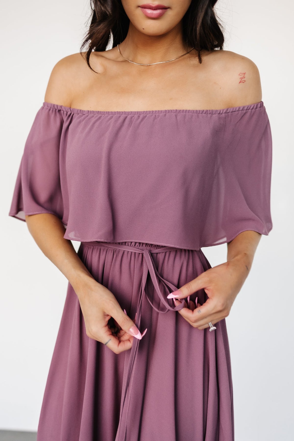 Fabric detail of vintage plum polyester showing soft drape, subtle texture, and the lightweight weave used for the lined maxi silhouette.