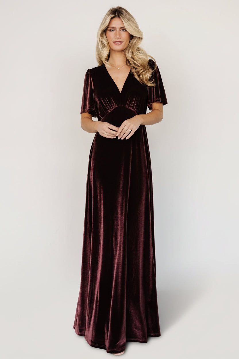 Front view of the Vivian Velvet Maxi Dress in Clove, showing deep V-neckline, gathered bust, flutter sleeves, and a flowing, floor-length velvet skirt.