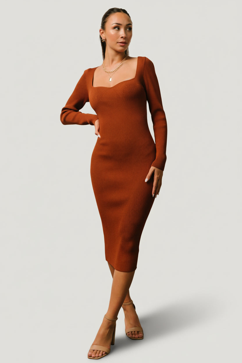 Three-quarter side view of the chestnut ribbed midi dress highlighting fitted waist, long sleeve drape, and smooth ribbed texture across the body.