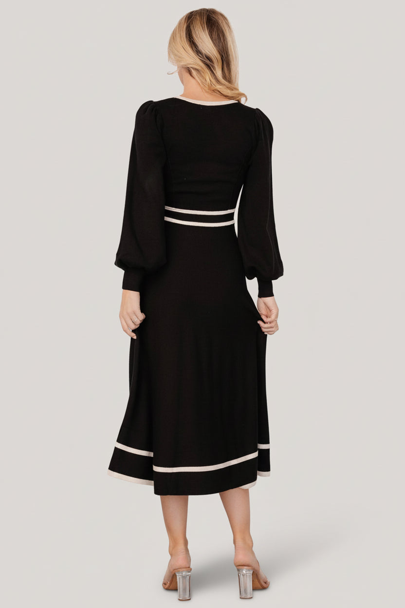 Lifestyle image of the Winslet knit dress styled with ankle boots, showing midi length, waist shaping and versatile styling.