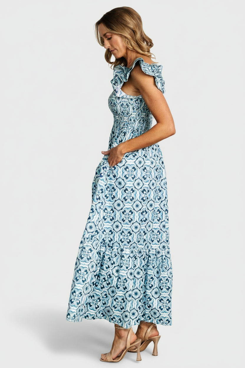 Back view showing square back and gentle gathering at waist with smocked bodice, tiered skirt movement and lined bottom tier visible.