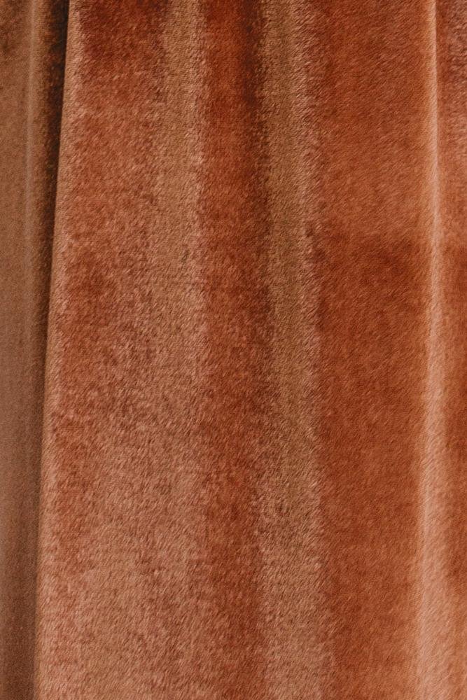 Close-up view of Spice Meghan velvet fabric swatch showing pile texture, warm orange-brown hue, and slight stretch; sample approximately 3 by 4 inches.