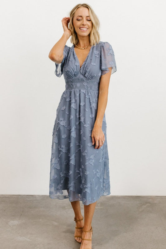 Front view of blue floral burnout chiffon midi dress showing V-neck, smocked waist, and flowing skirt, ideal for wedding guests and events.