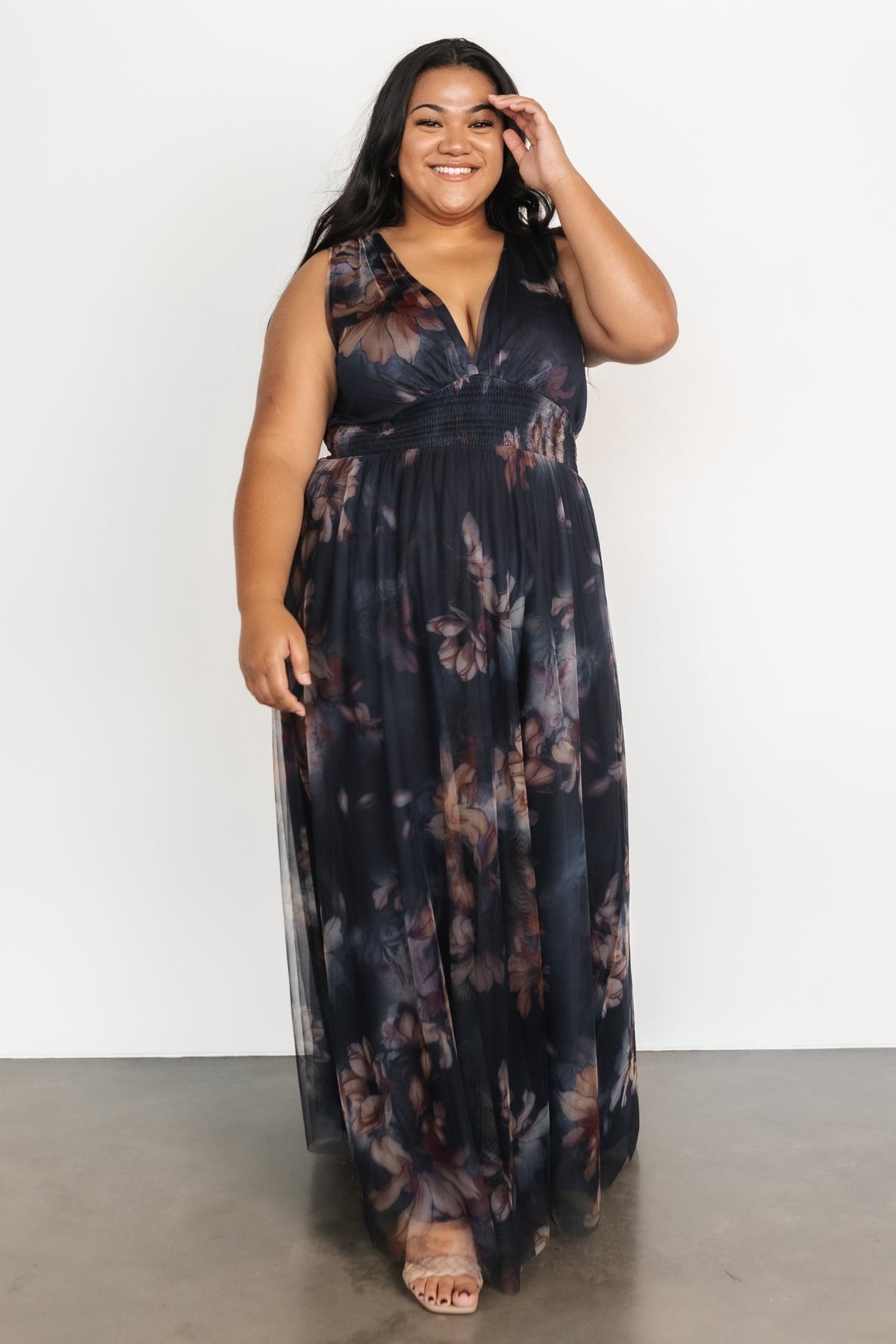 Three-quarter angle of dark blue floral tulle maxi dress highlighting short tank sleeves, bodice shaping and flowing layered tulle skirt.