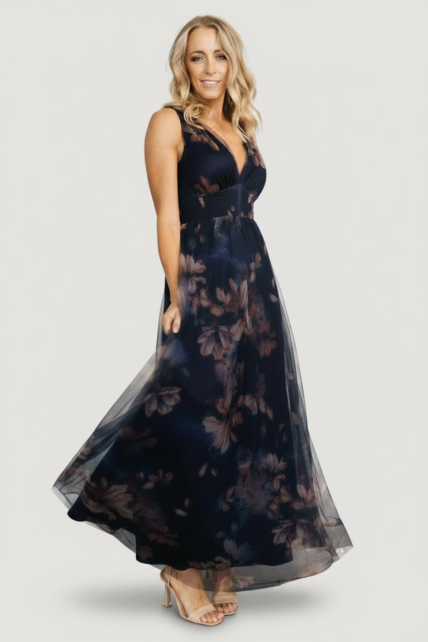 Movement shot of the dark blue floral tulle maxi dress showing layered tulle skirt in motion and its soft, voluminous drape.
