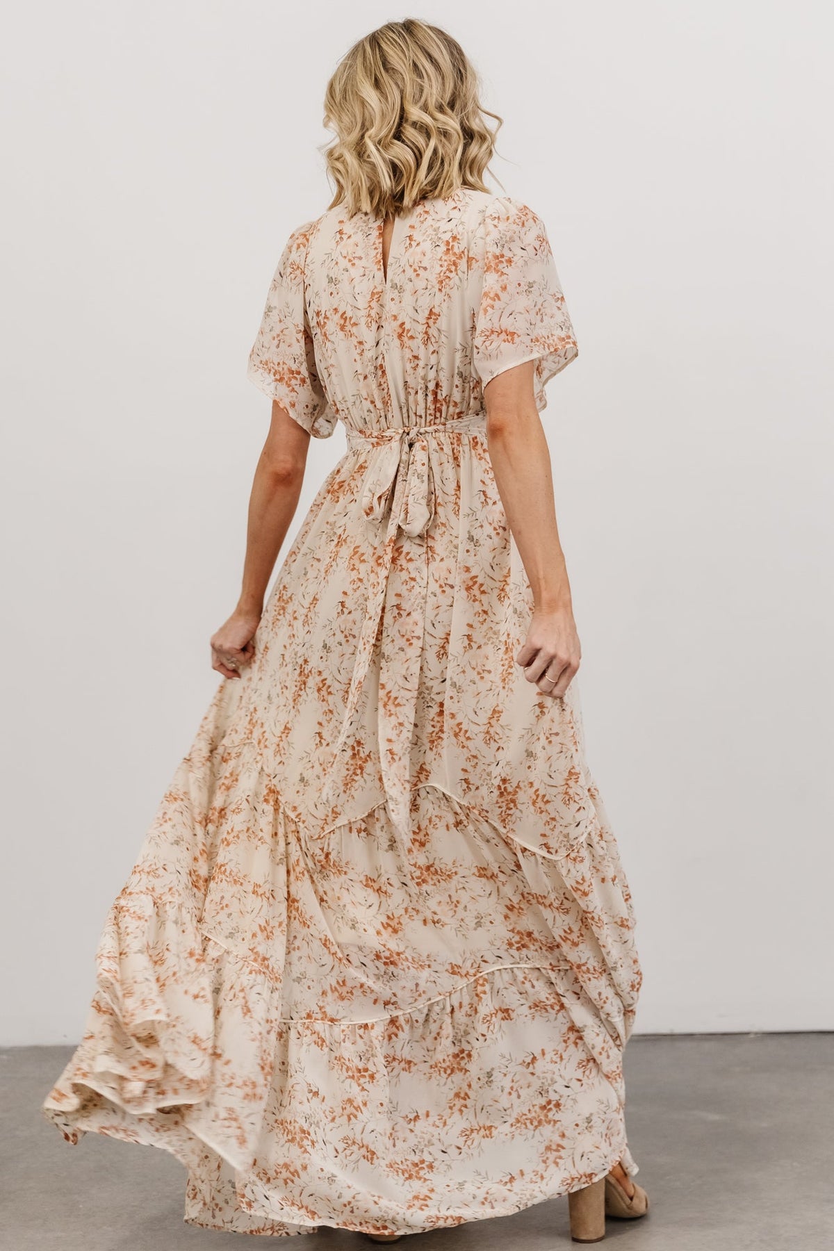 Waist detail close-up showing attached side ties and subtle gathering at the surplice waist on the floral chiffon dress.